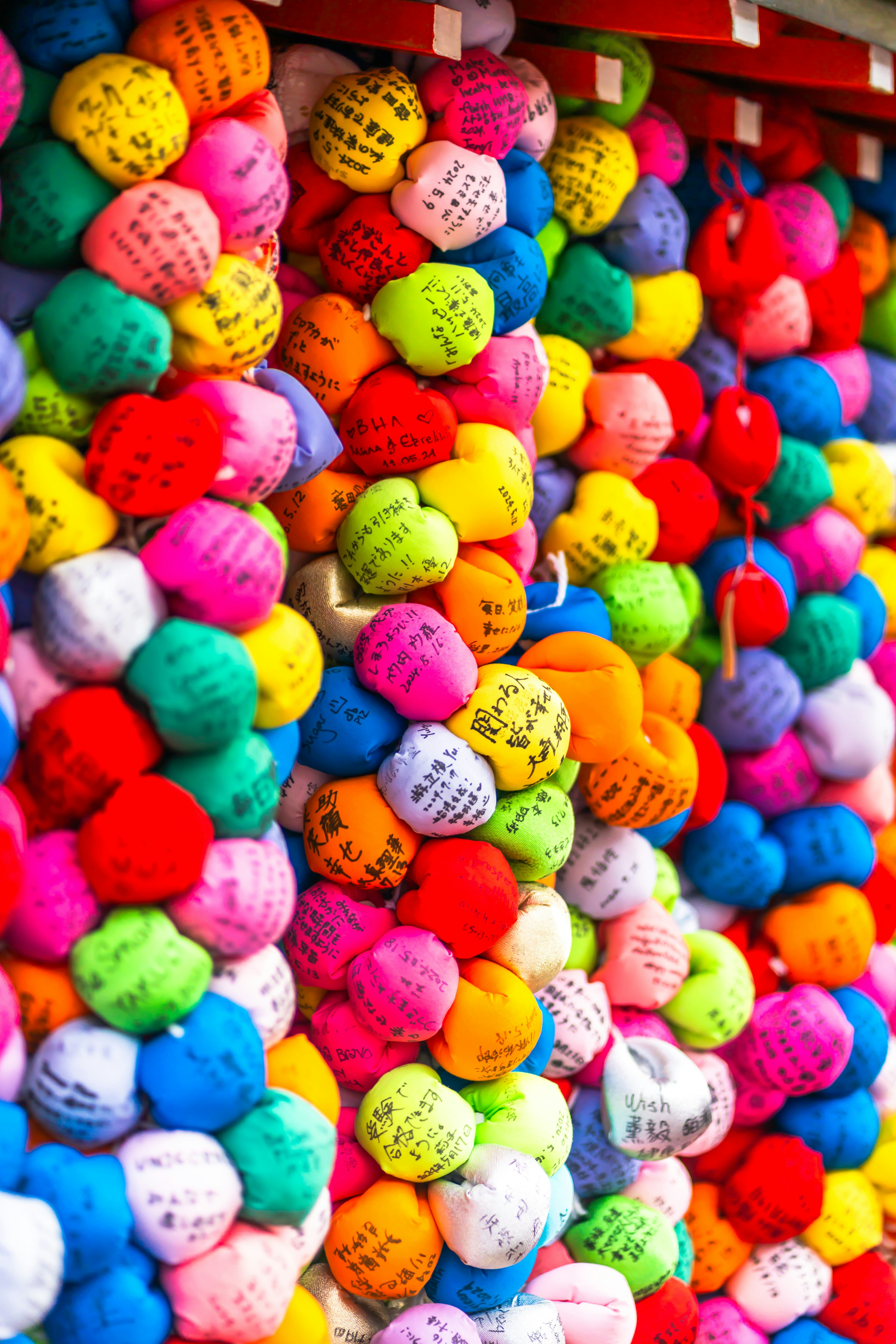 Boules de fil colorées disposées sur un mur