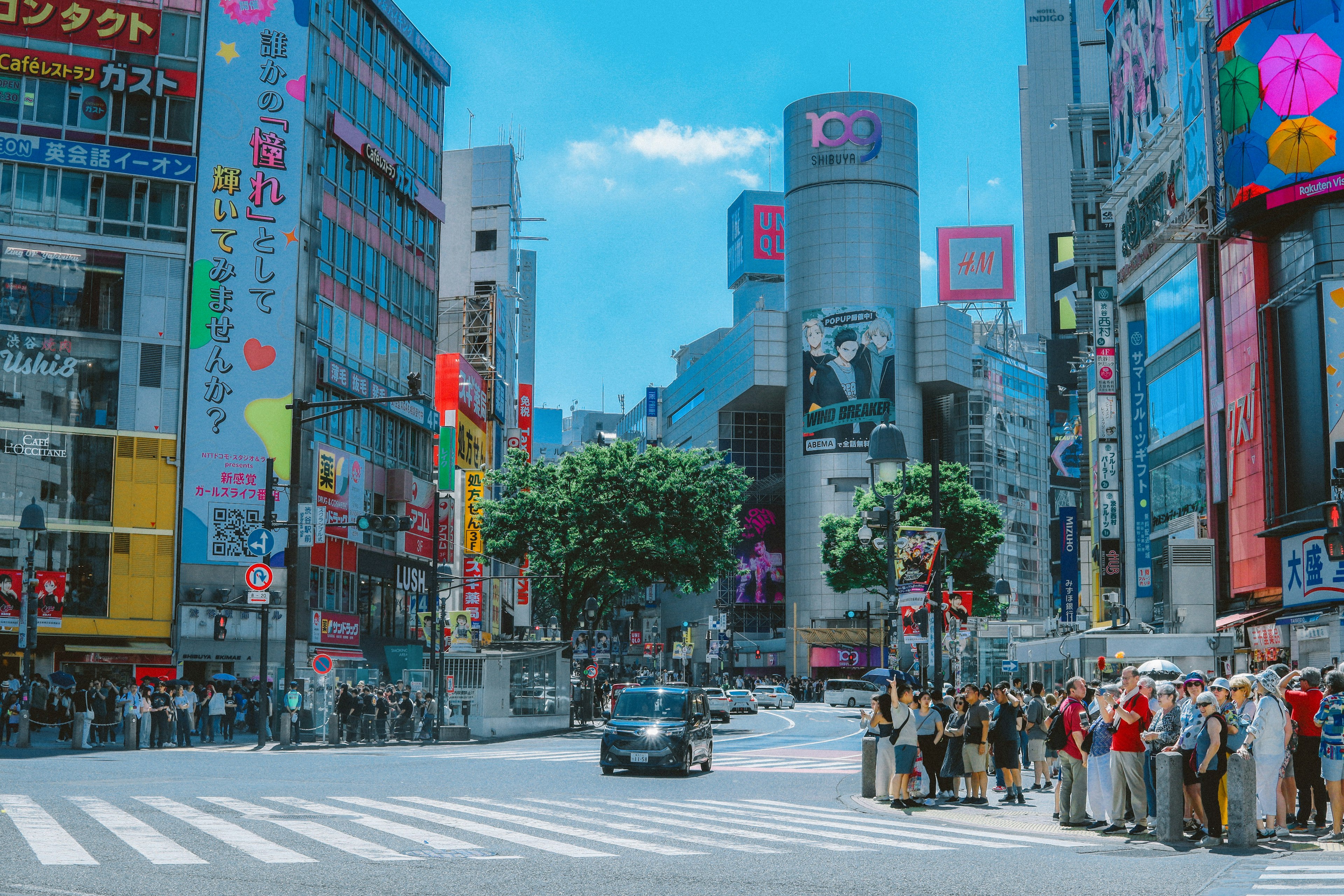 渋谷の交差点に人々が並んでいる様子と高層ビルが立ち並ぶ背景