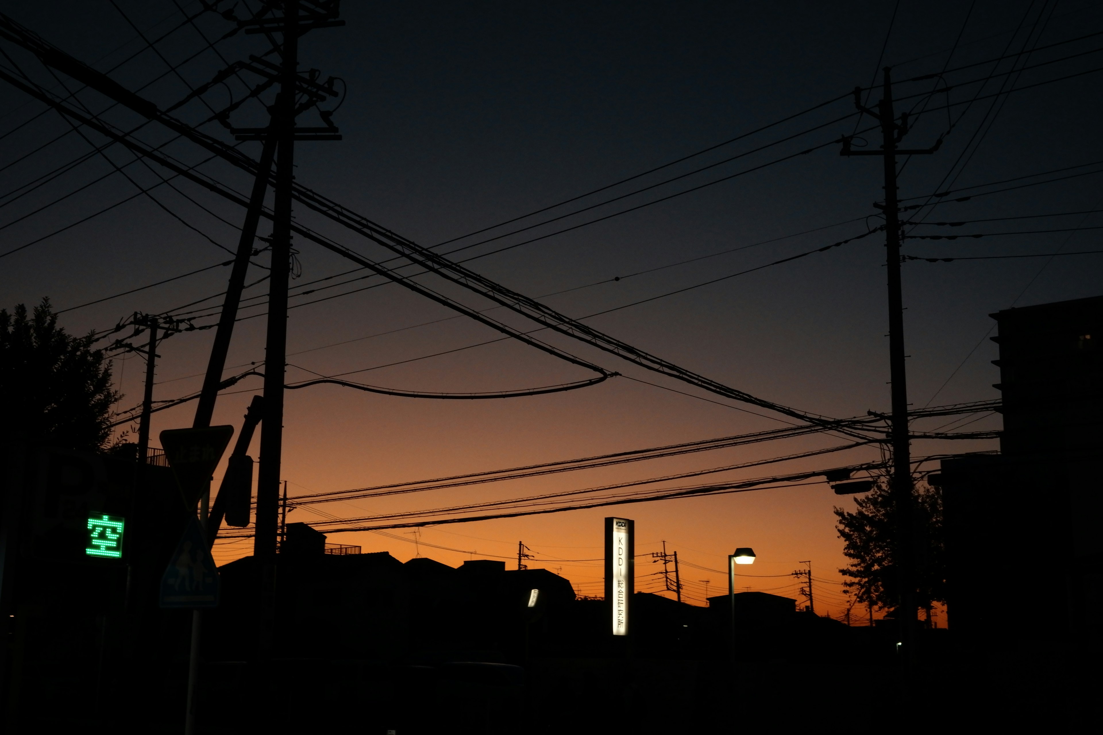 Silhouette di una città al crepuscolo con linee elettriche