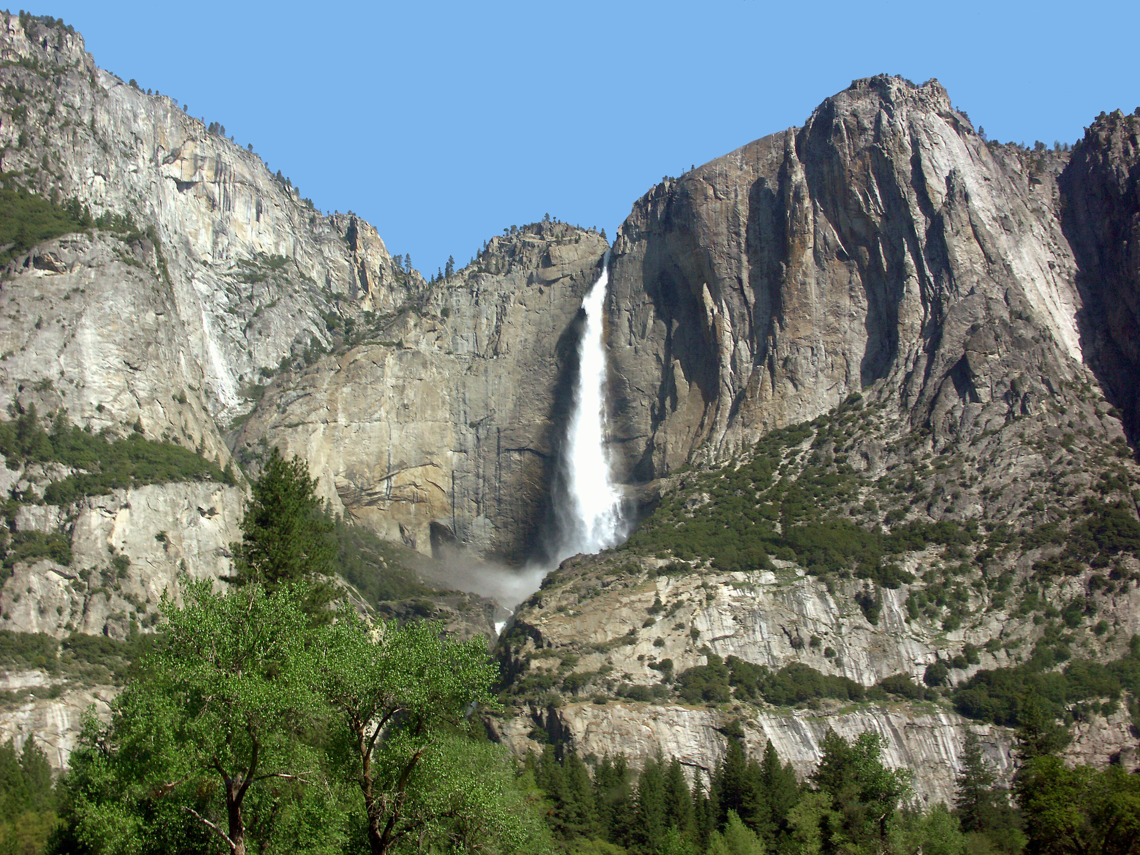 Scenic view of a waterfall in Yosemite National Park surrounded by rocky mountains