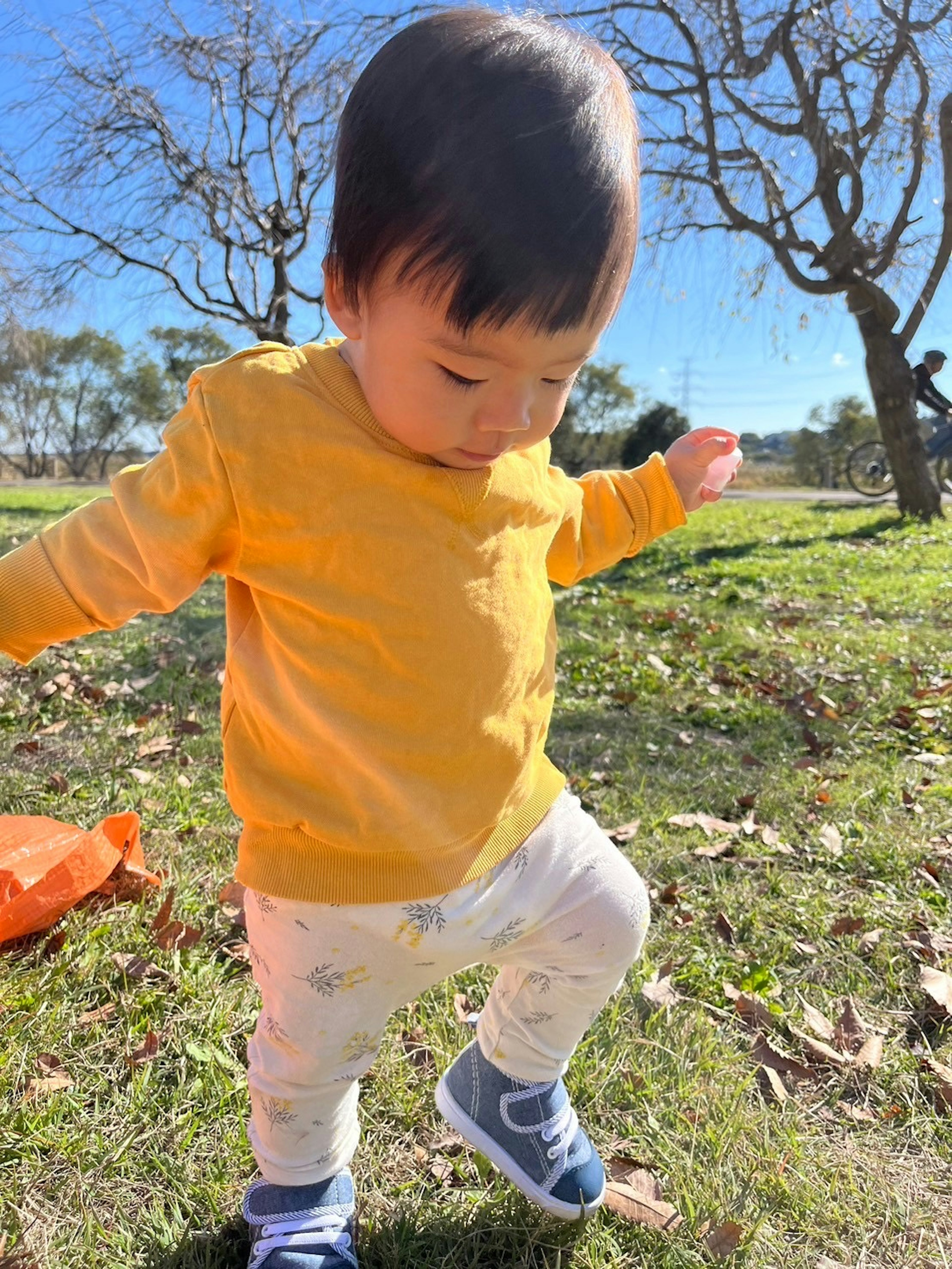 公園で遊んでいる子供 黄色のシャツと白いズボンを着ている