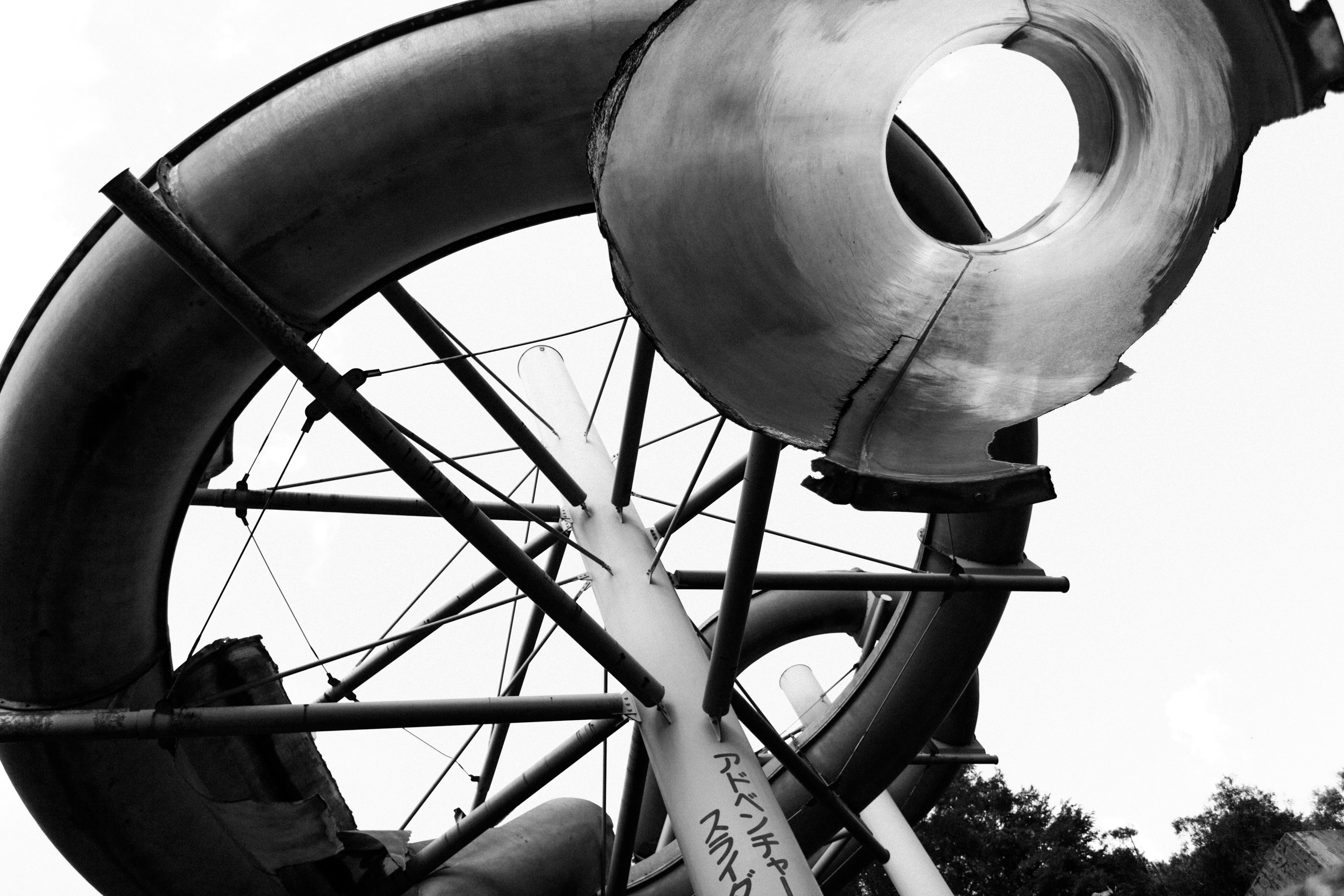 Foto en blanco y negro de una estructura de tobogán con un gran tubo y un marco de soporte