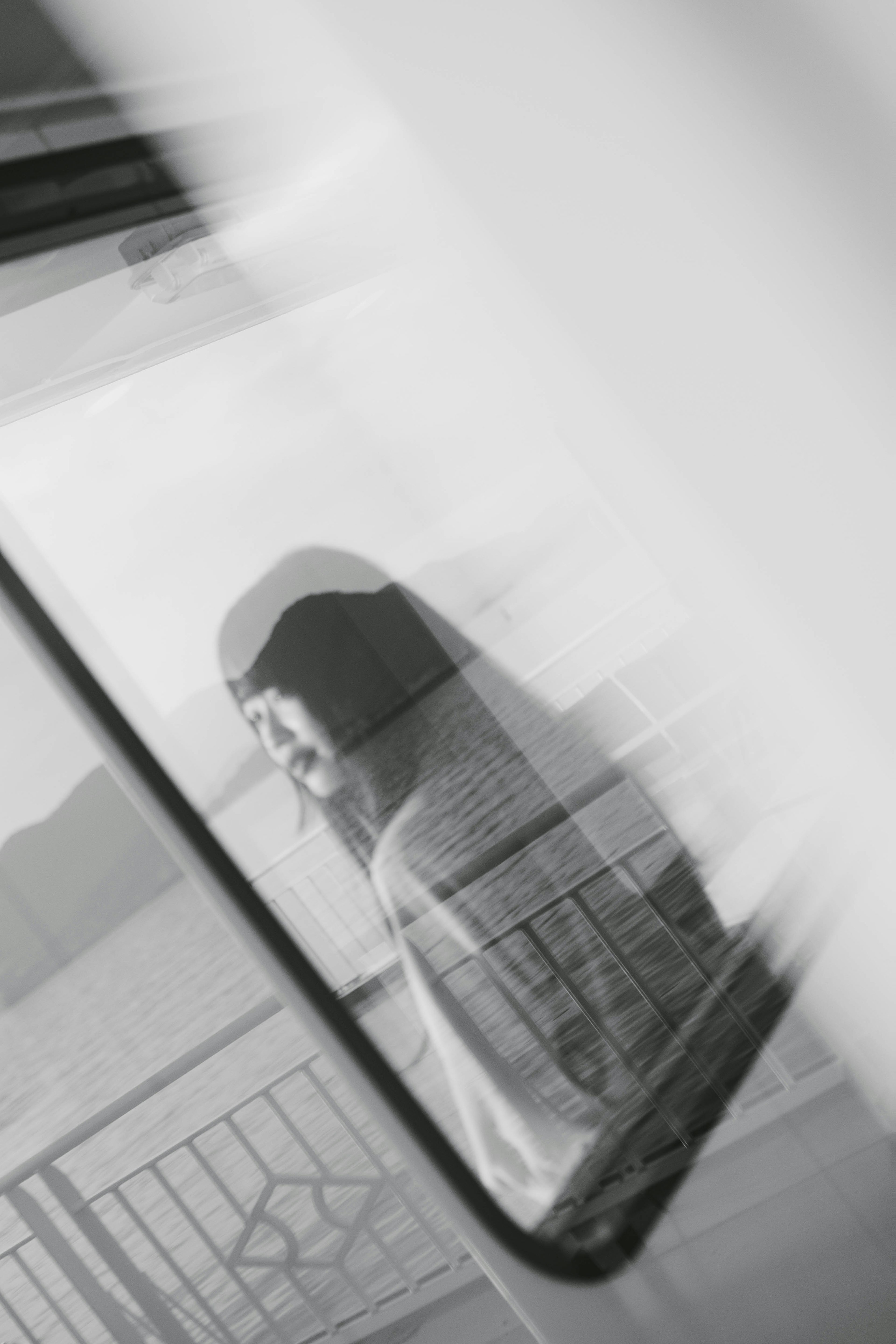 A woman gazing out a window in a black and white image