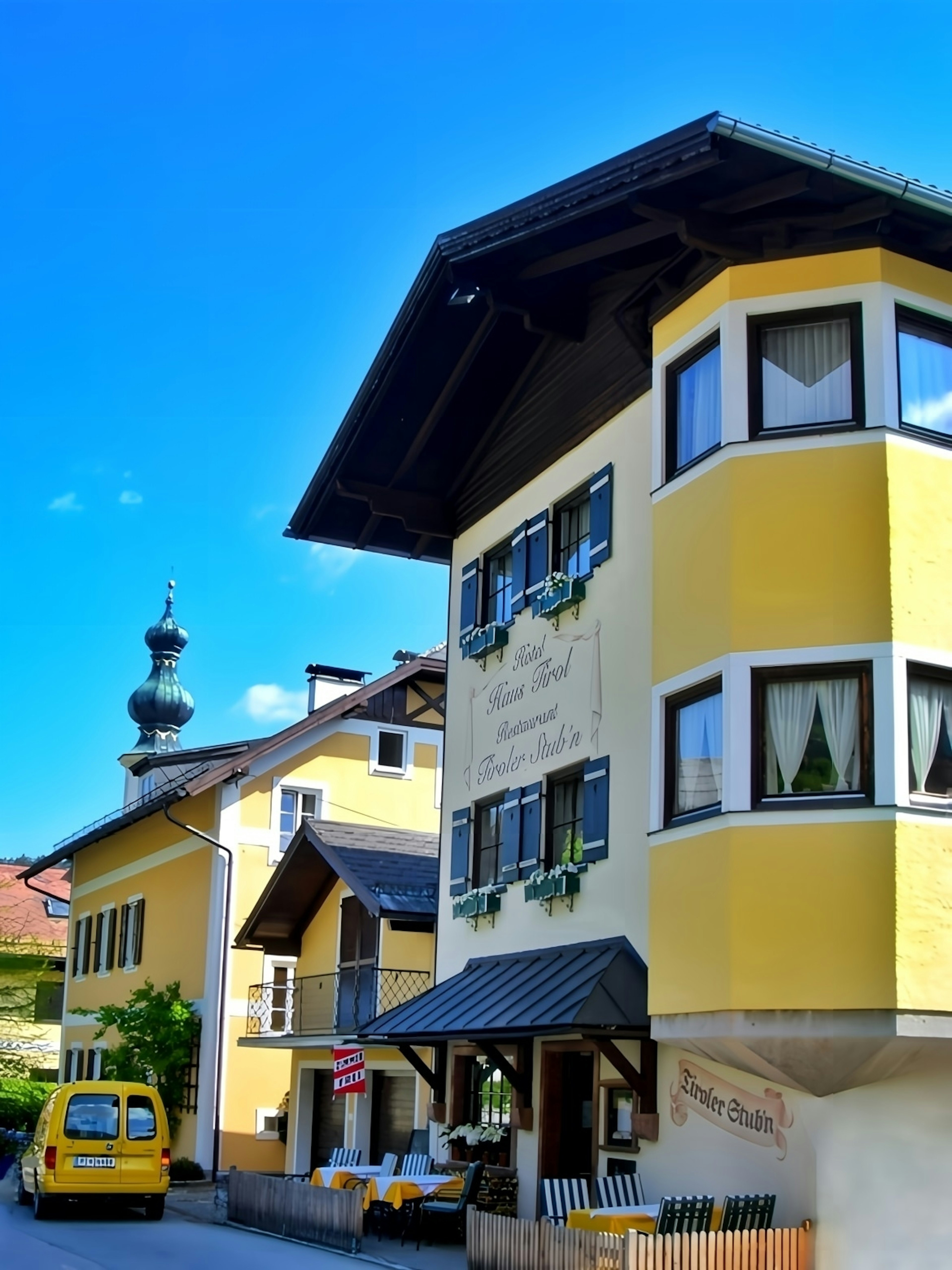 Casa tradicional con exterior amarillo bajo un cielo azul claro