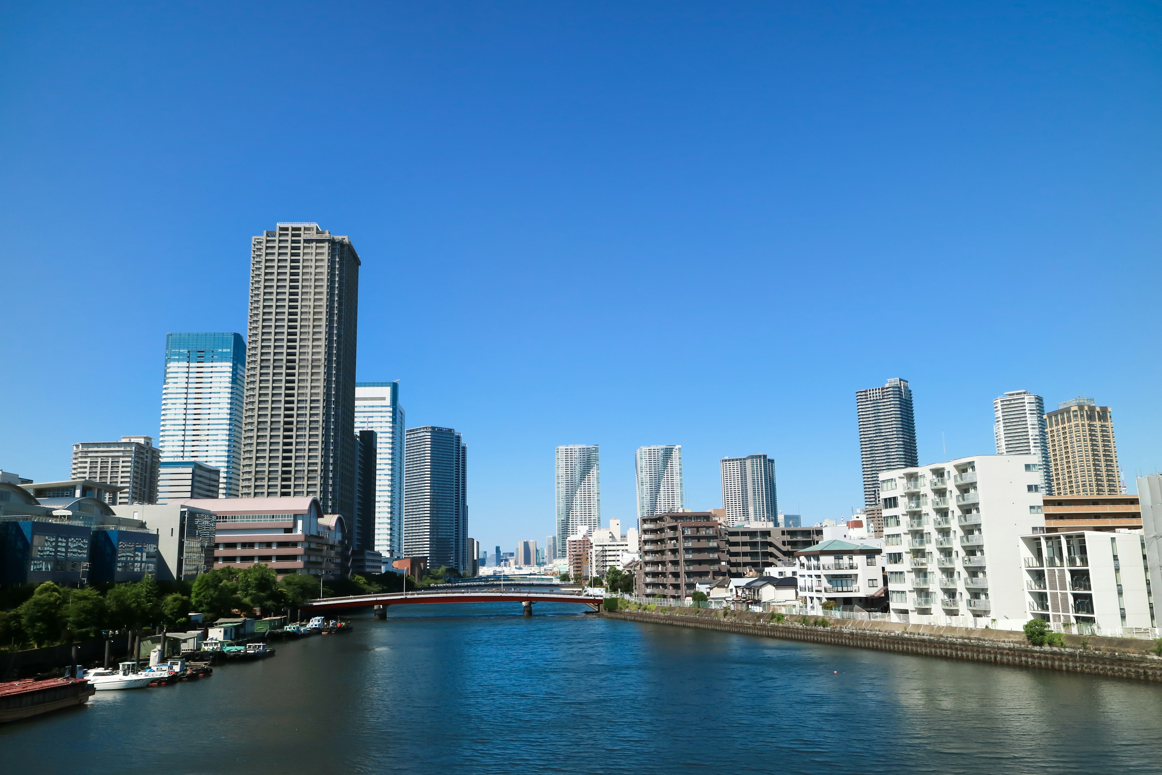 在晴朗蓝天下的城市景观，有摩天大楼和一条河流