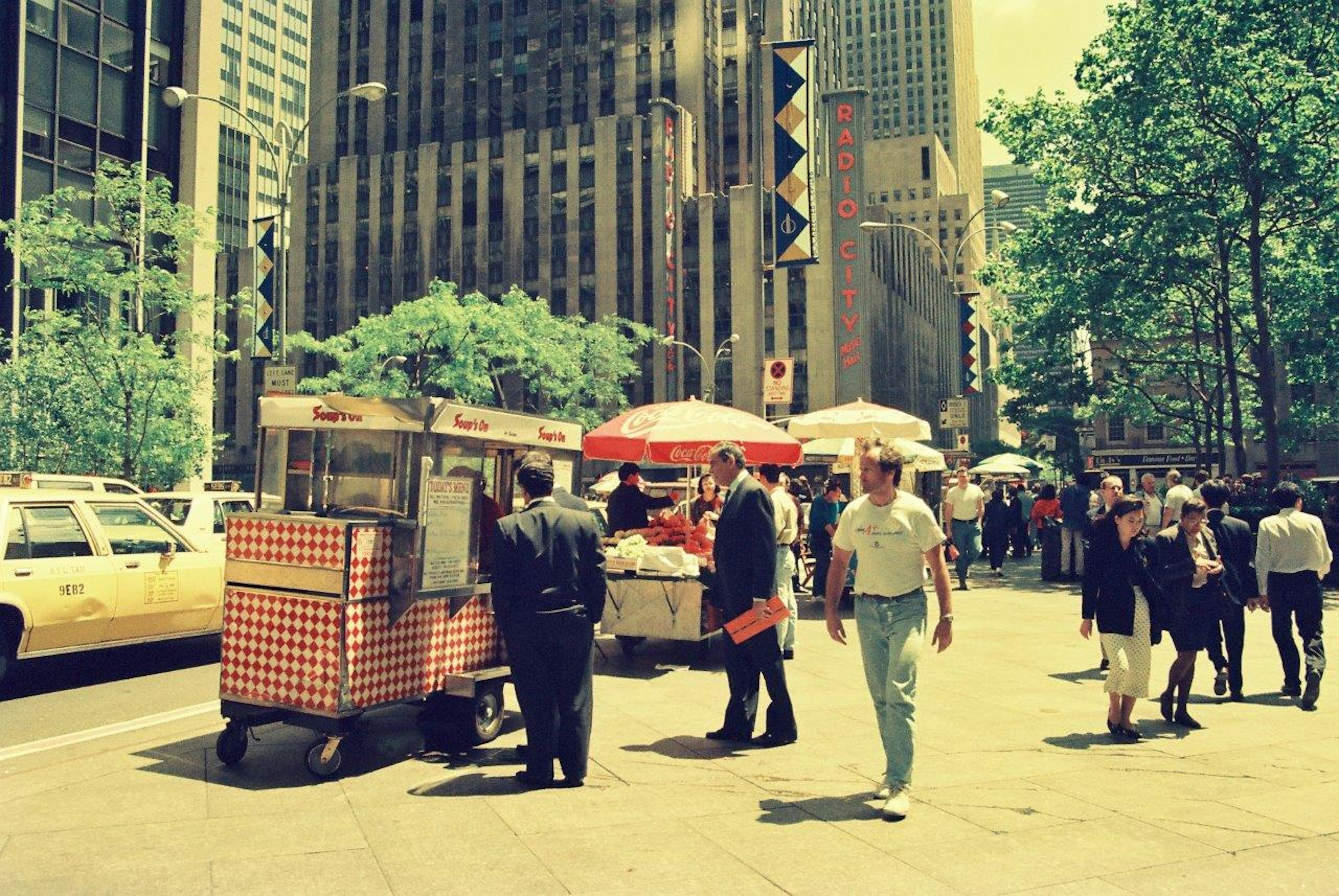 Street scene featuring a hot dog stand and pedestrians