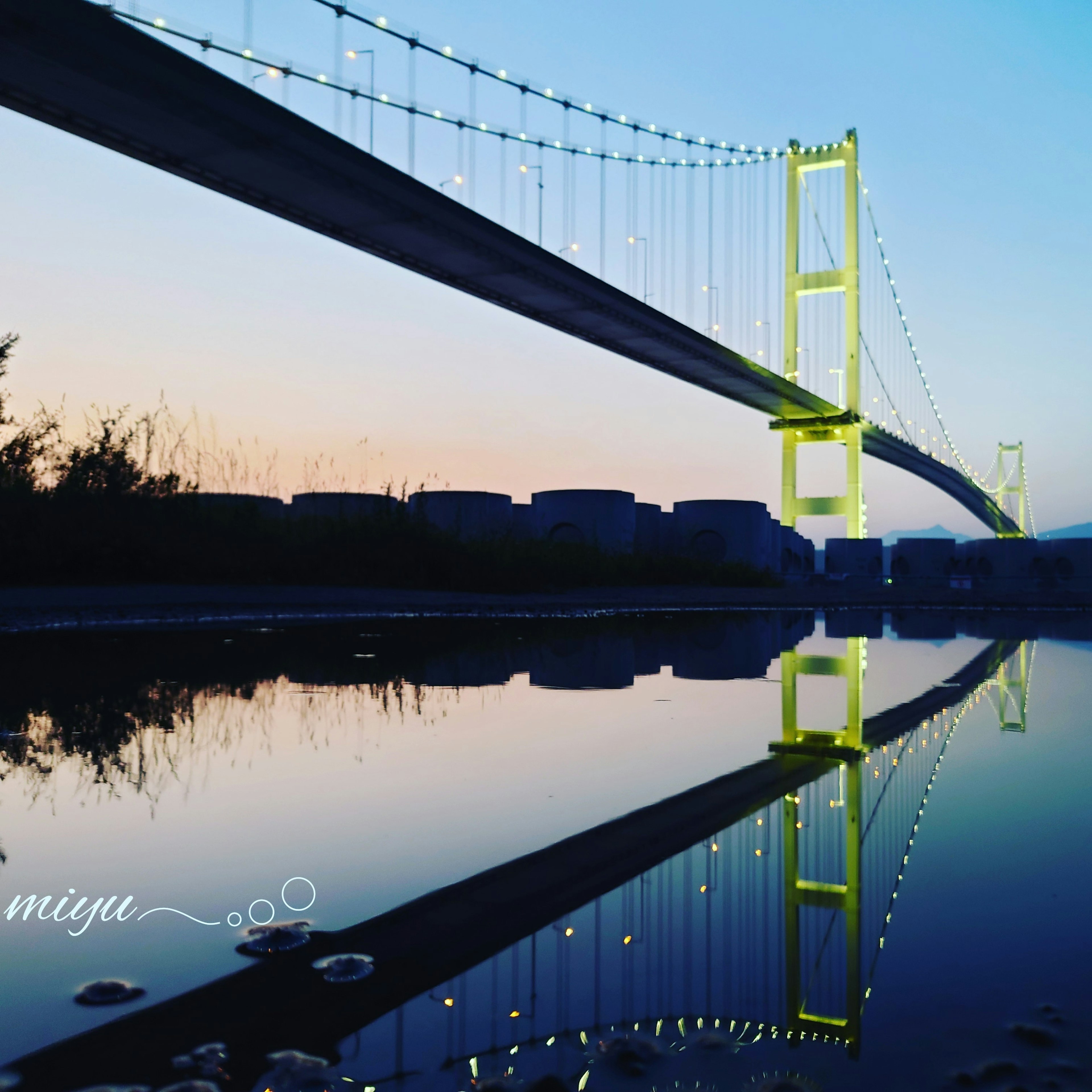 Belle réflexion du pont au coucher du soleil avec des lumières