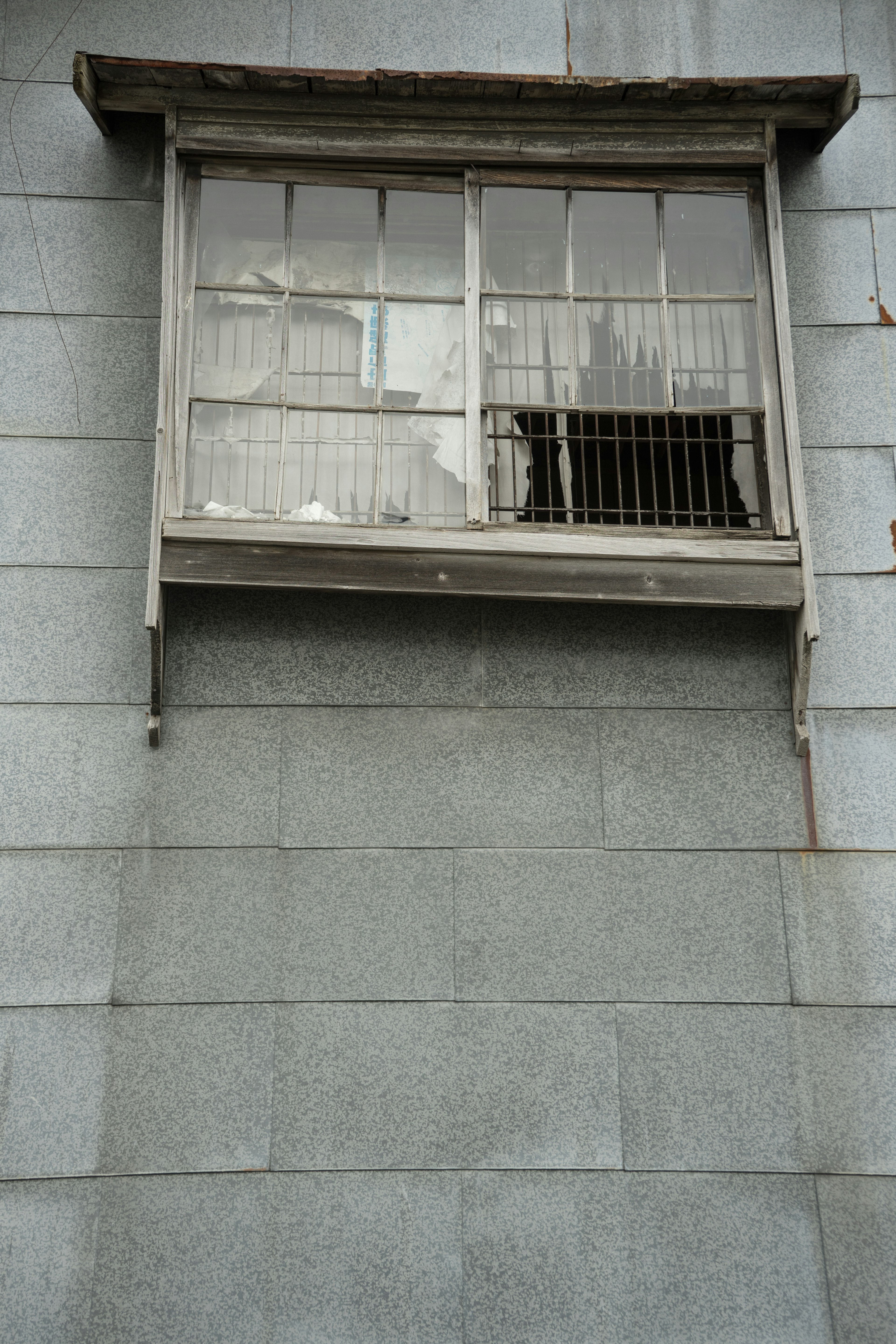 Une fenêtre avec des barreaux sur un vieux bâtiment