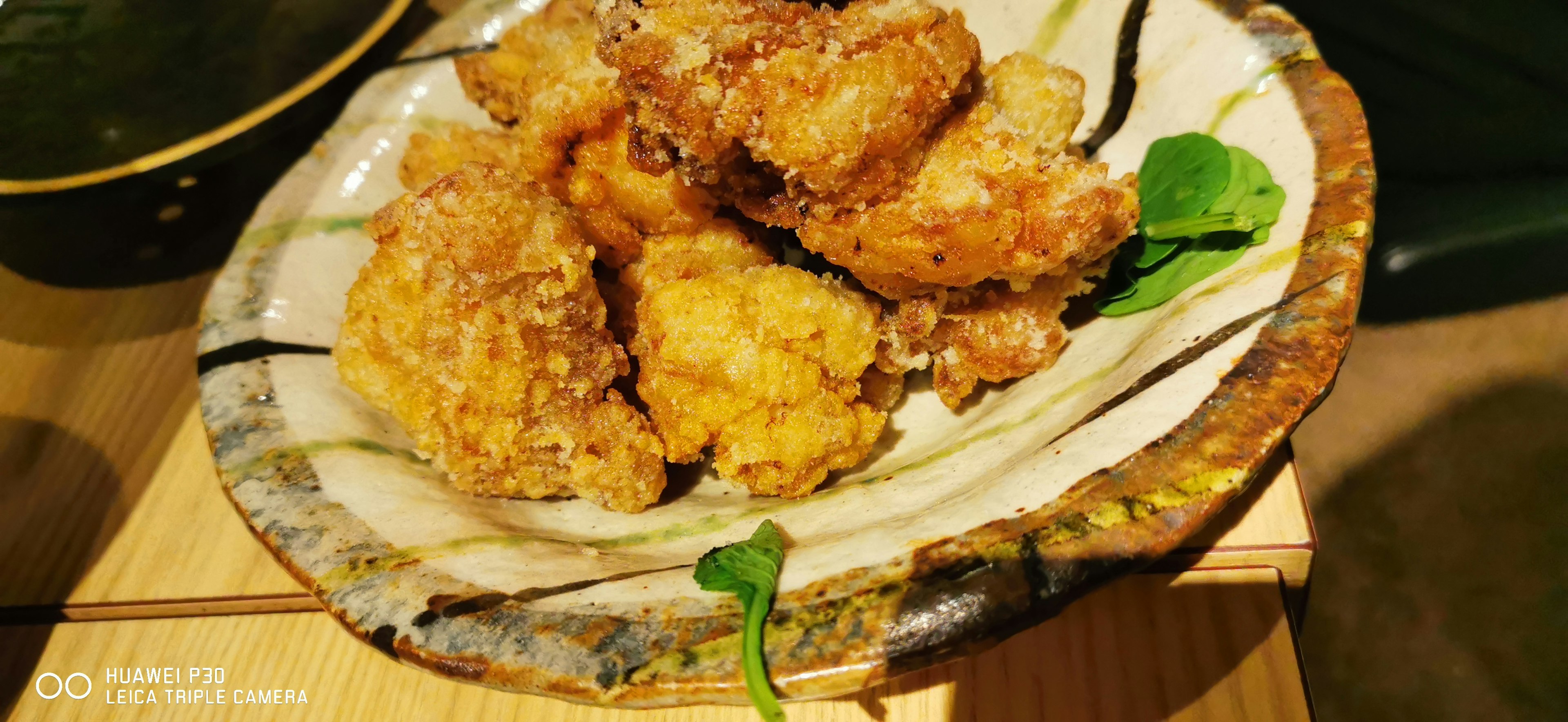 Un plato de trozos de pollo frito crujiente decorado con verduras