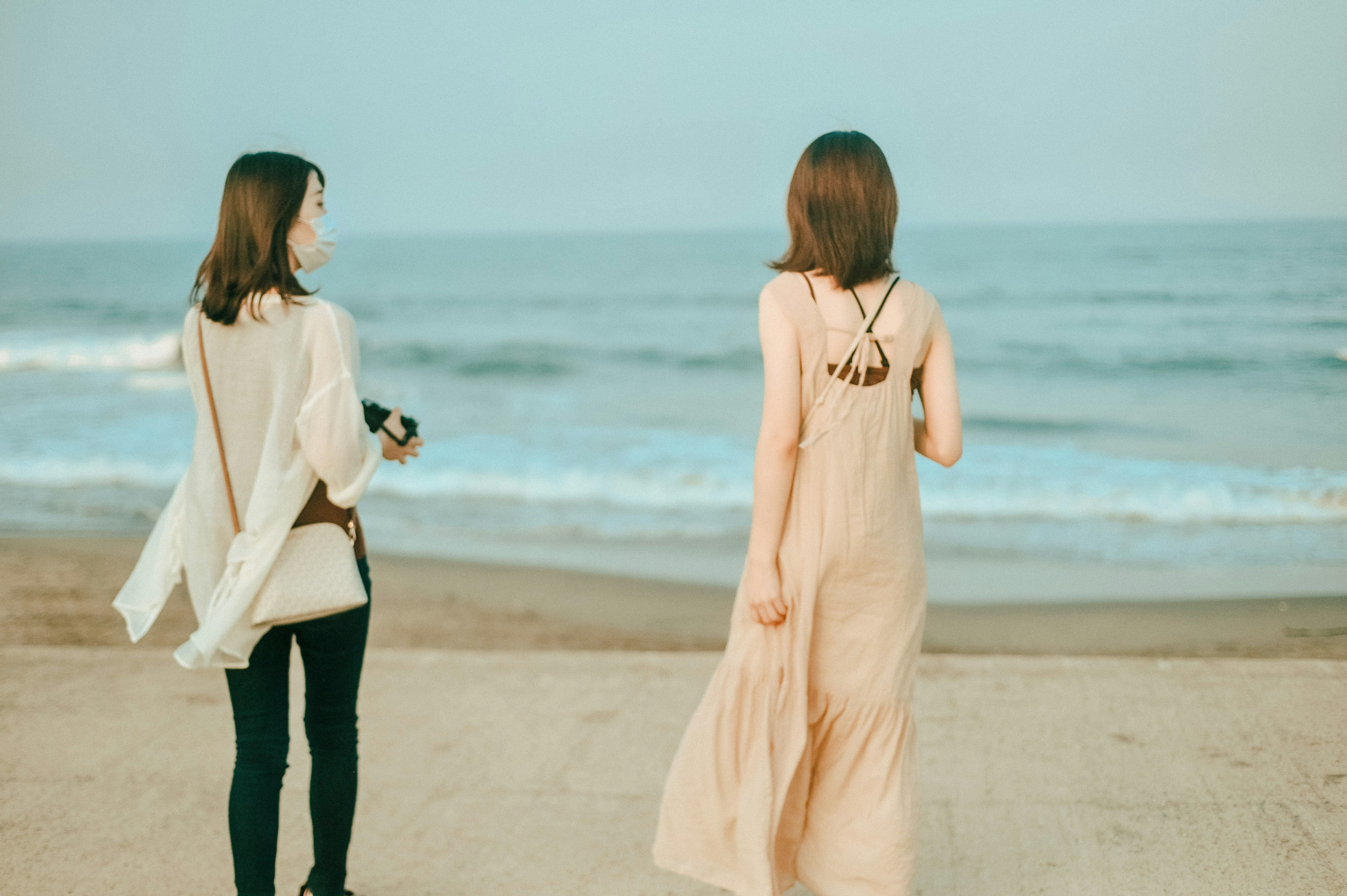 Zwei Frauen, die am Strand aufs Meer schauen