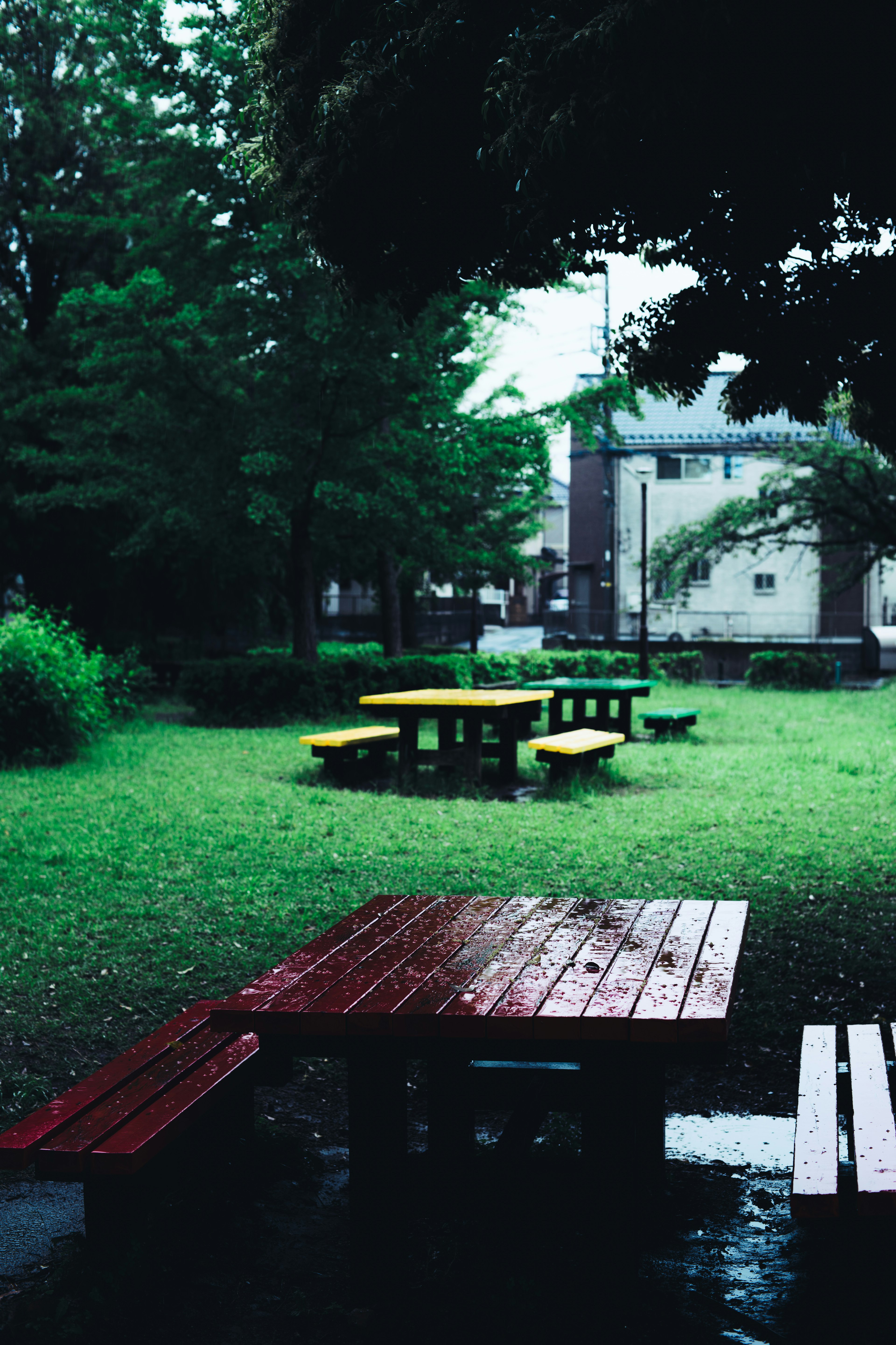 Rote und gelbe Picknicktische in einem grünen Park