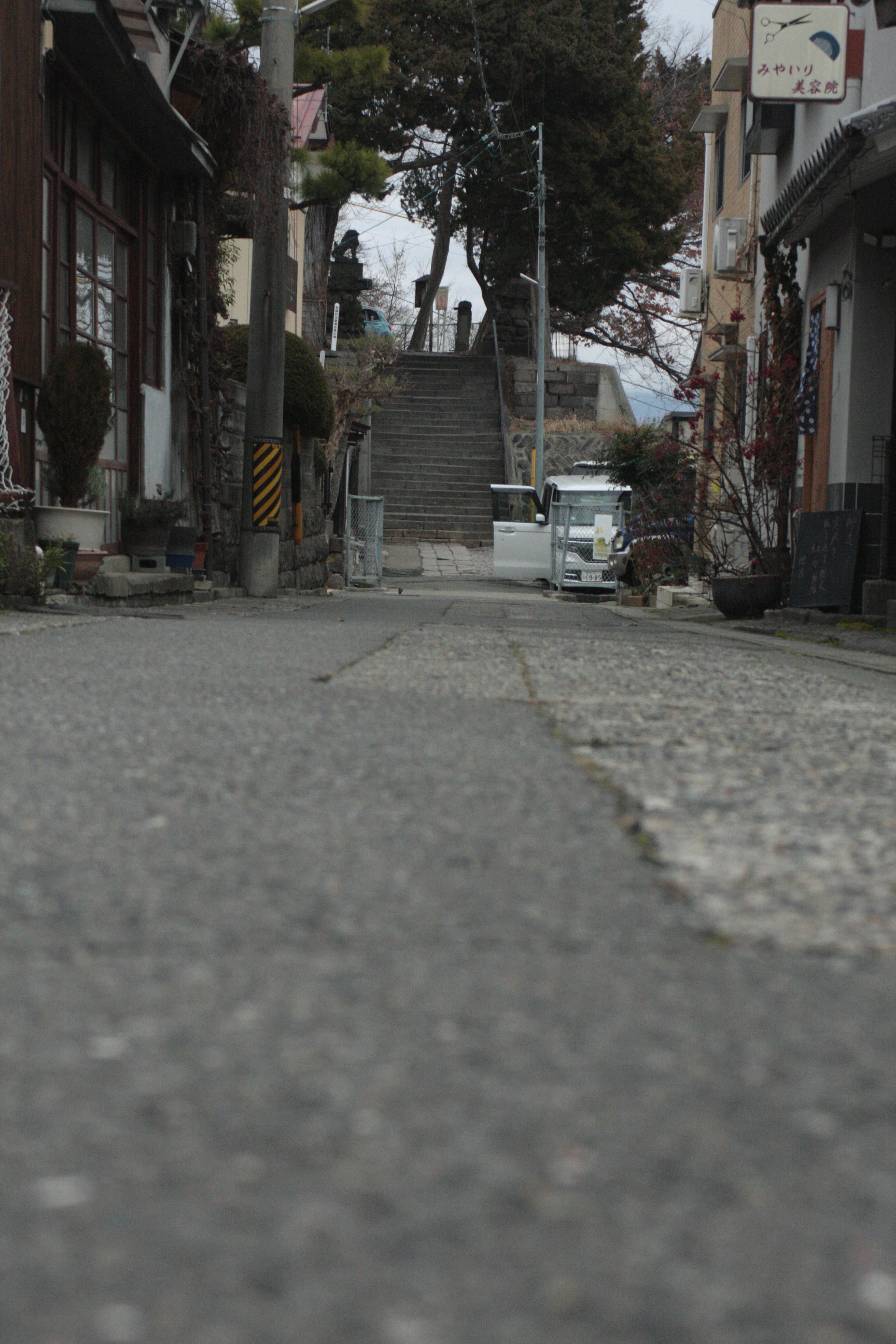 Quiet street scene with cobblestone road and visible stairs