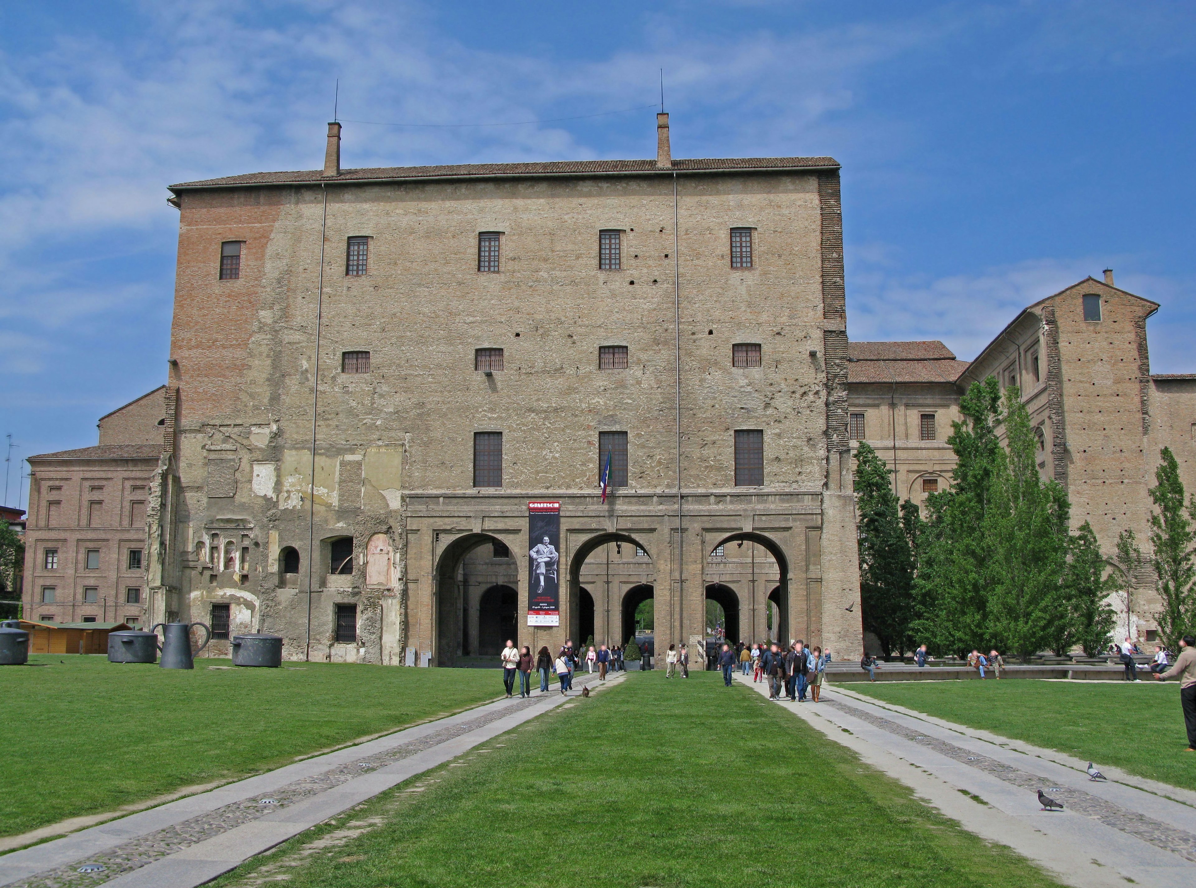 Historic building façade with people gathering on the lawn