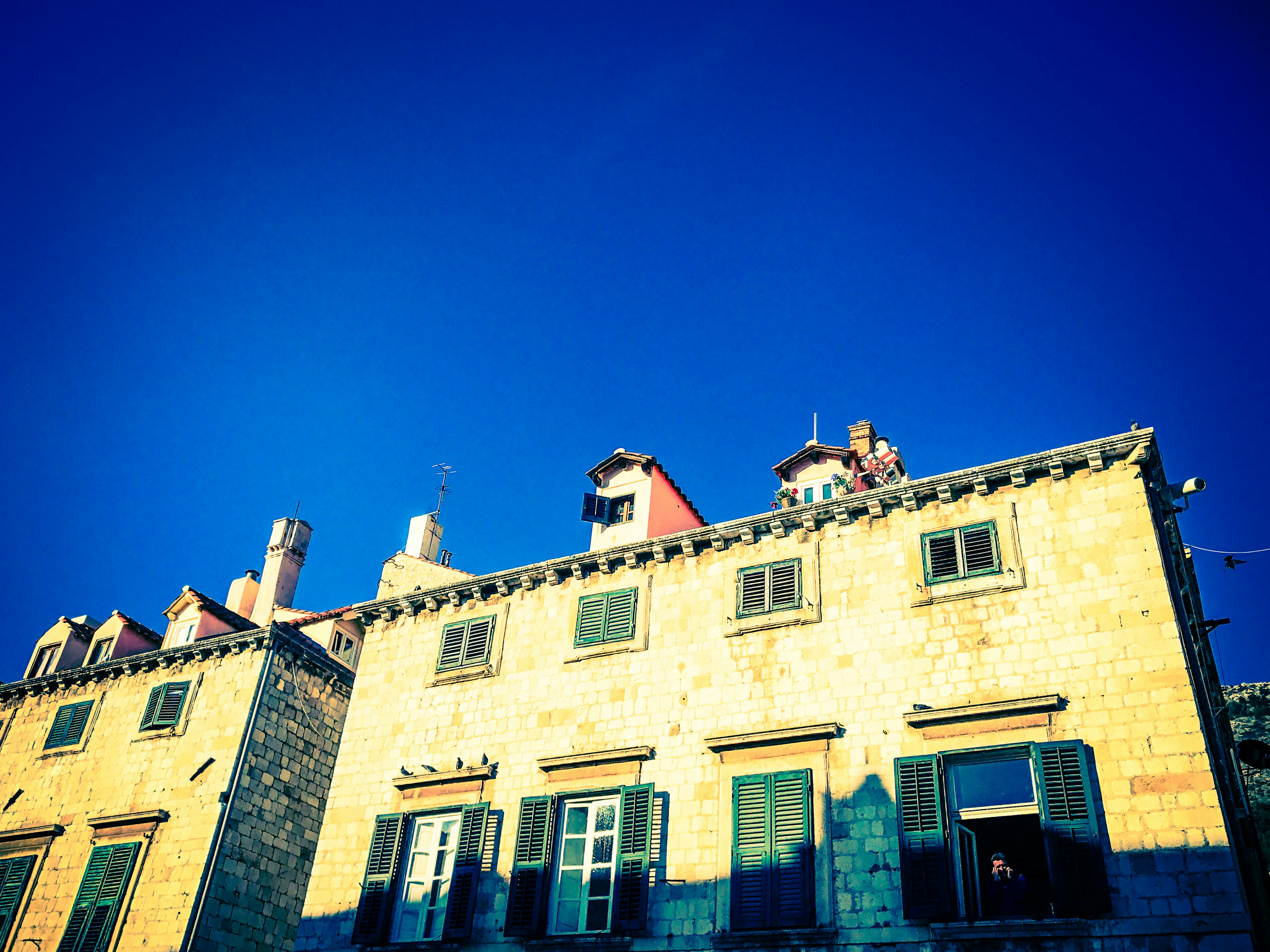 Fachada de casas de piedra bajo un cielo azul claro