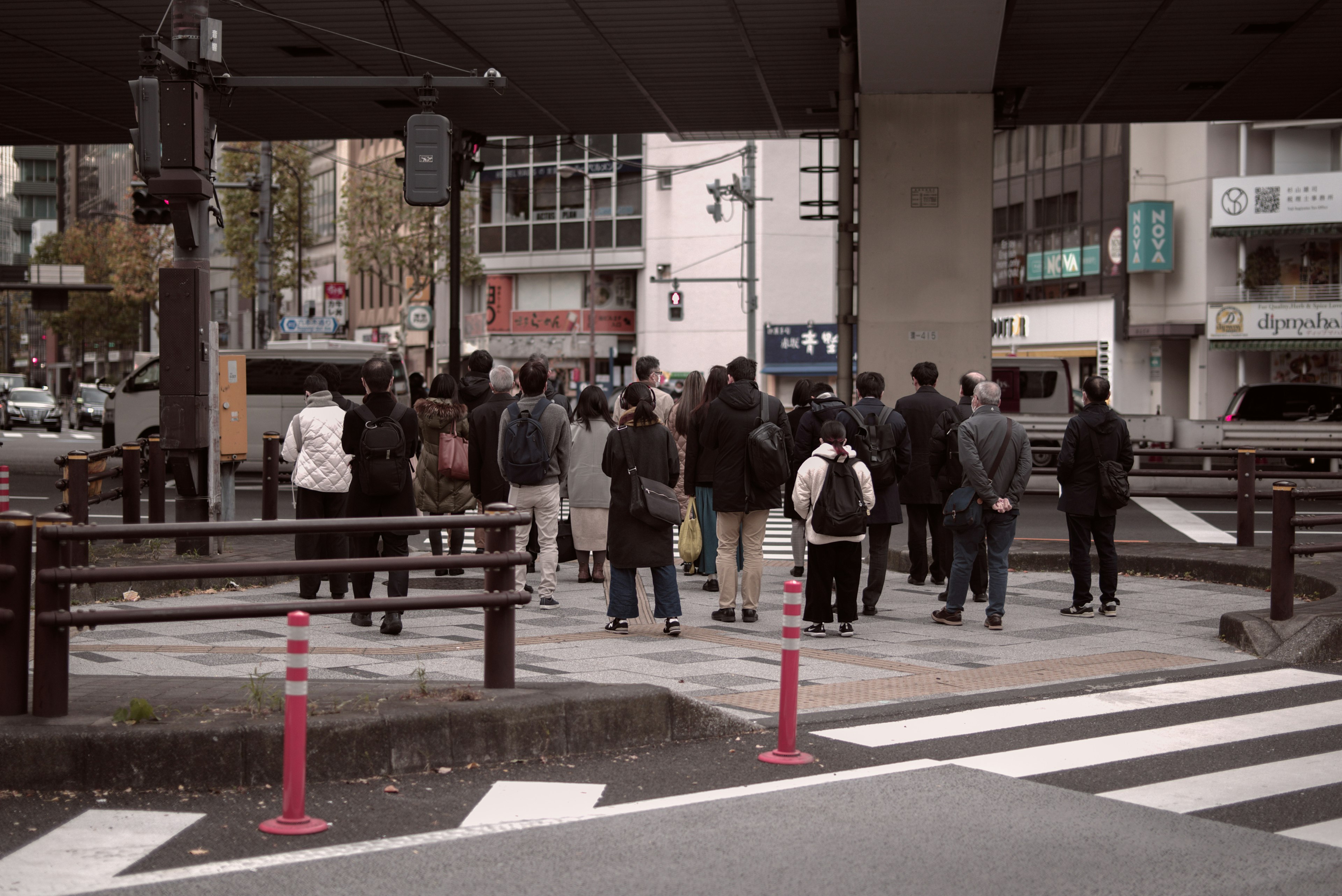 Des personnes attendant à un passage piéton avec un paysage urbain en arrière-plan