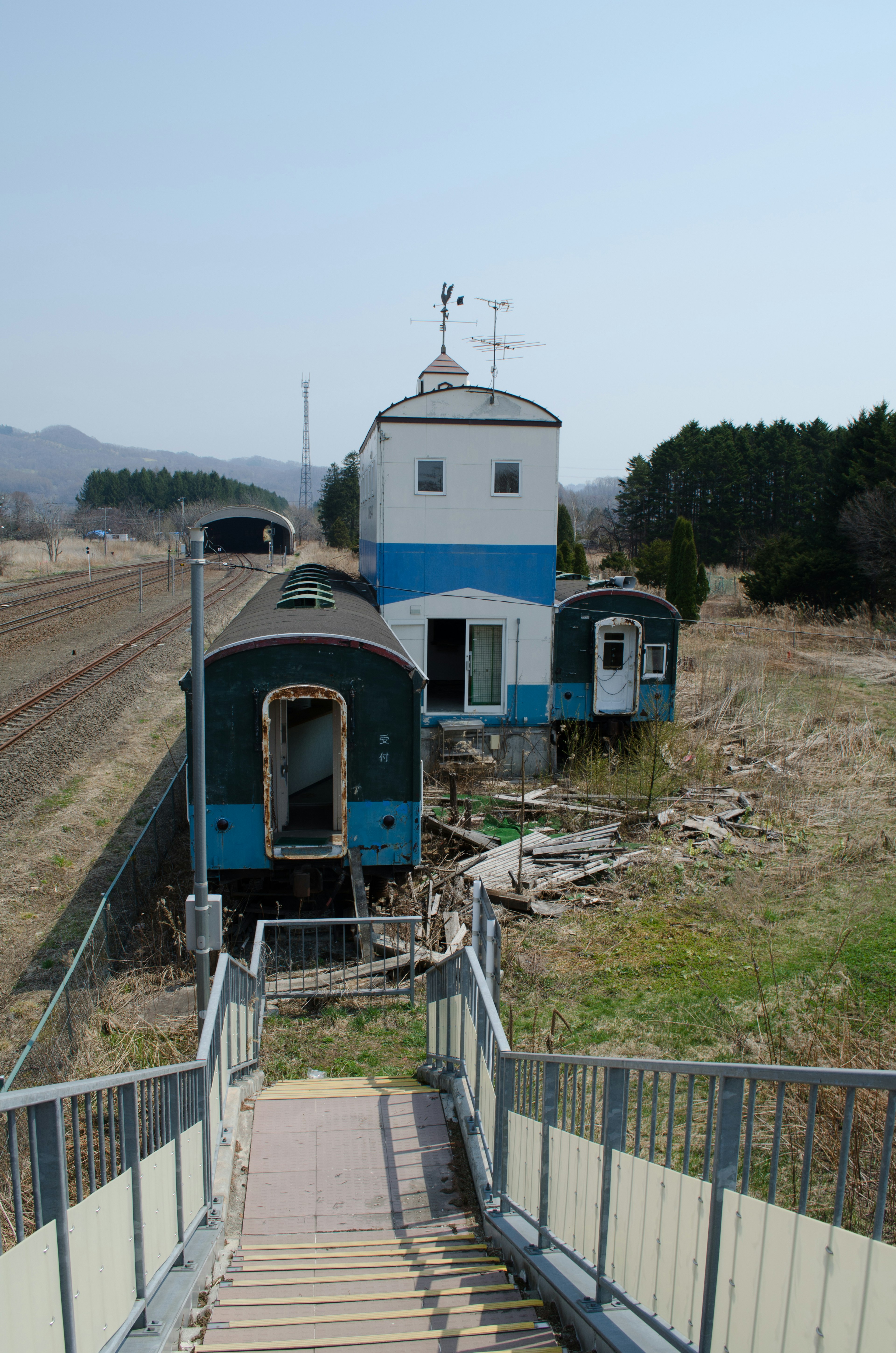 青い外壁の建物と古い列車がある風景