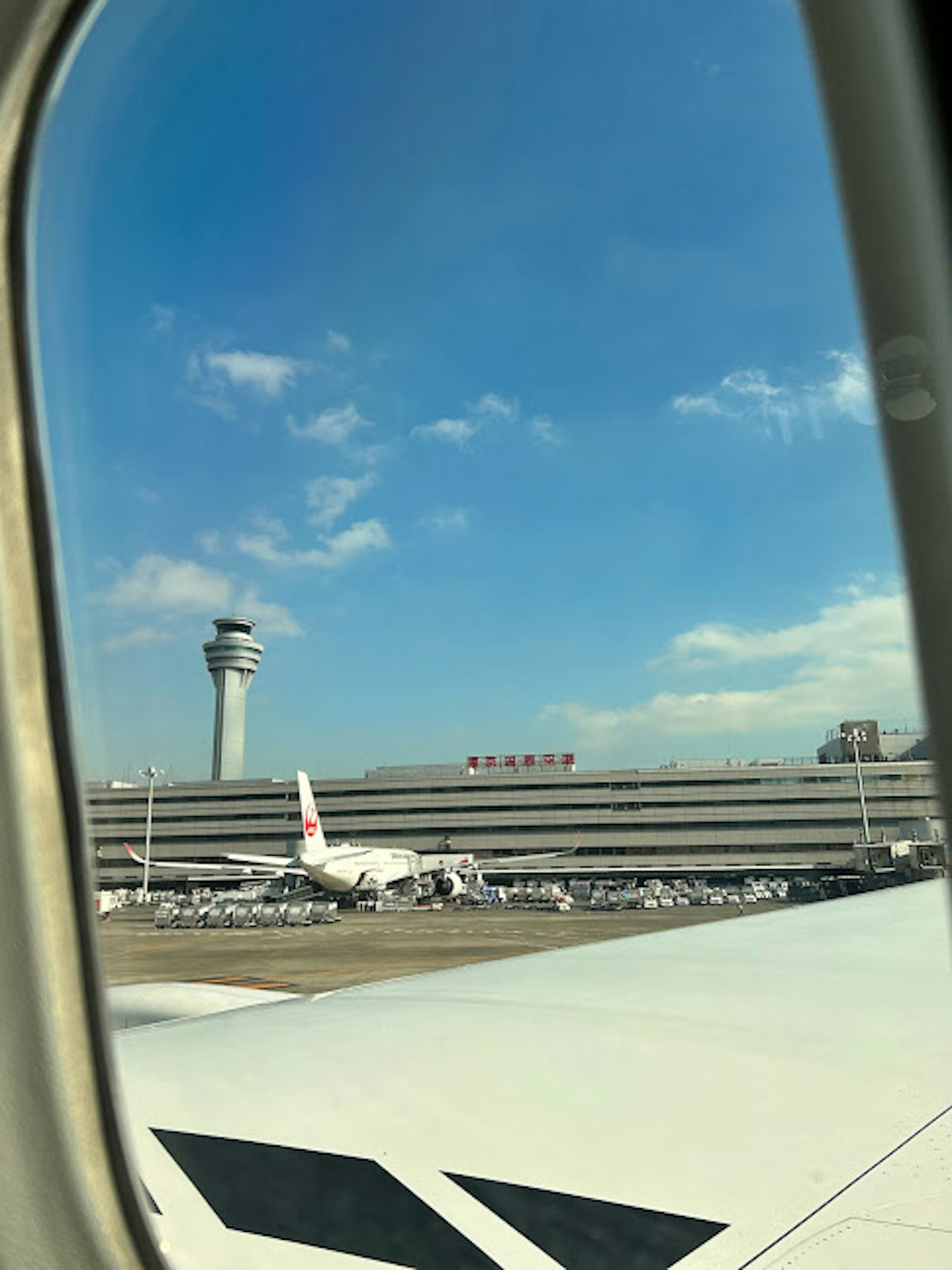 空港の滑走路と航空機が見える窓の外の風景