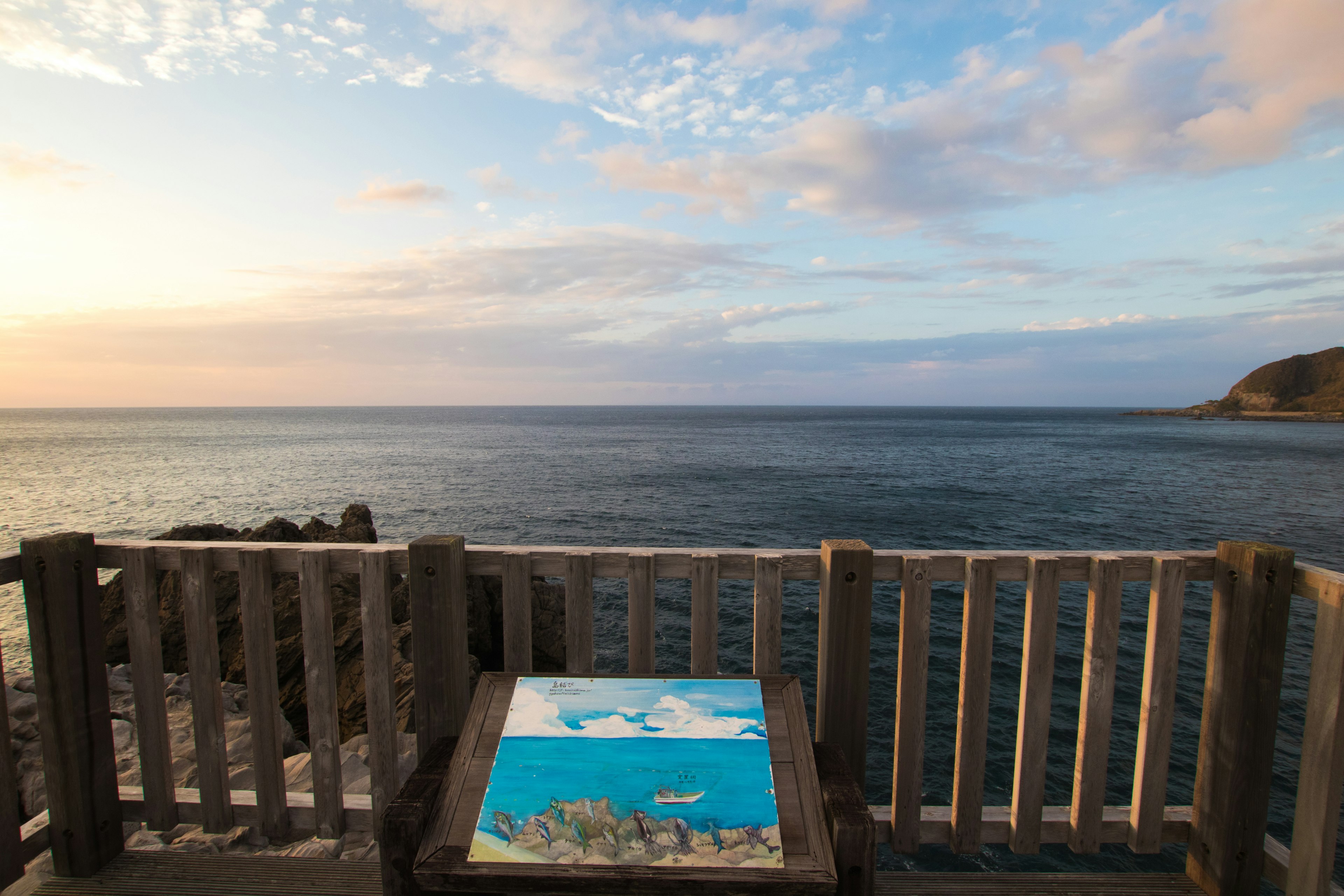 Scenic viewpoint overlooking the ocean with blue sky and clouds