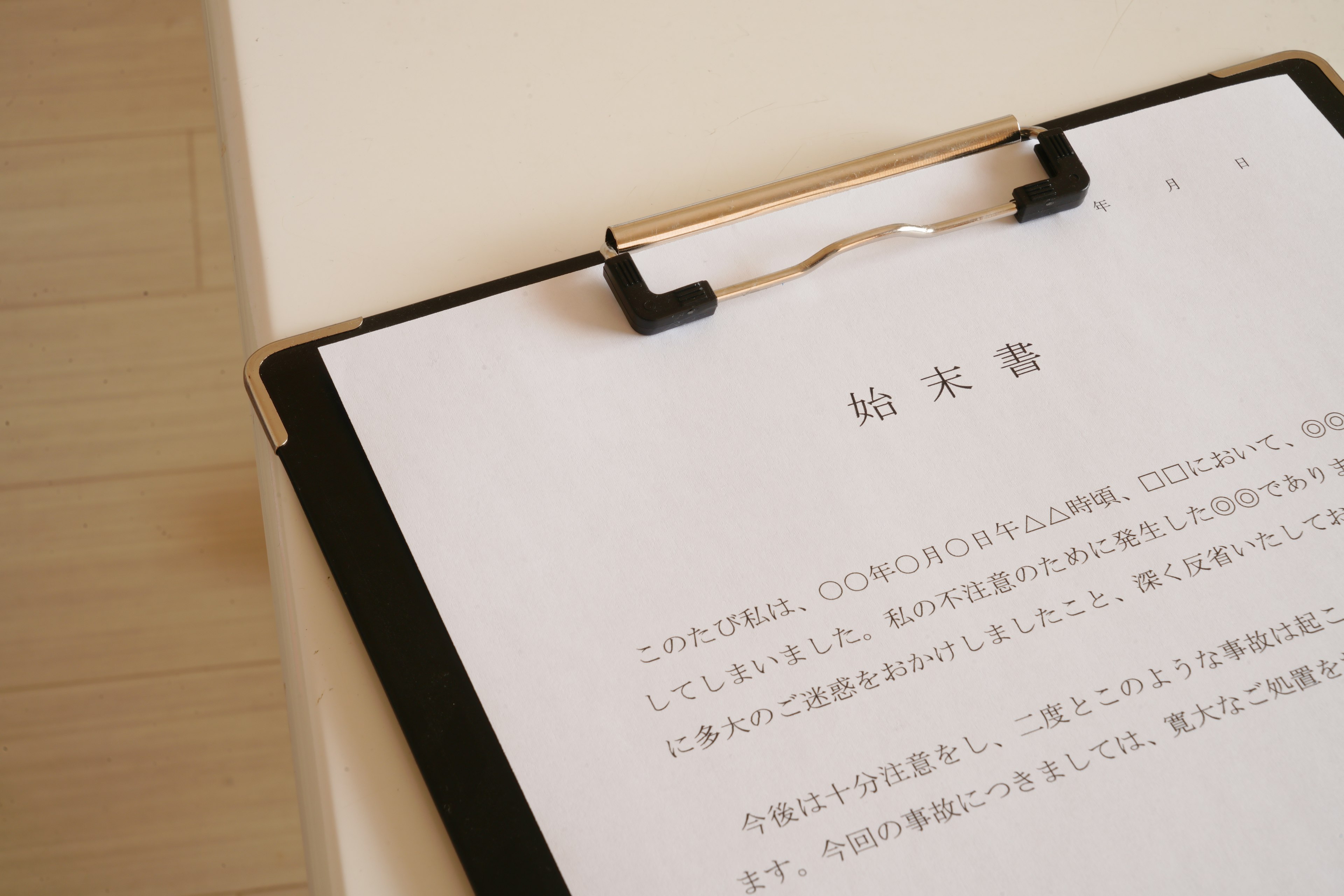 A document in Japanese resting on a clipboard