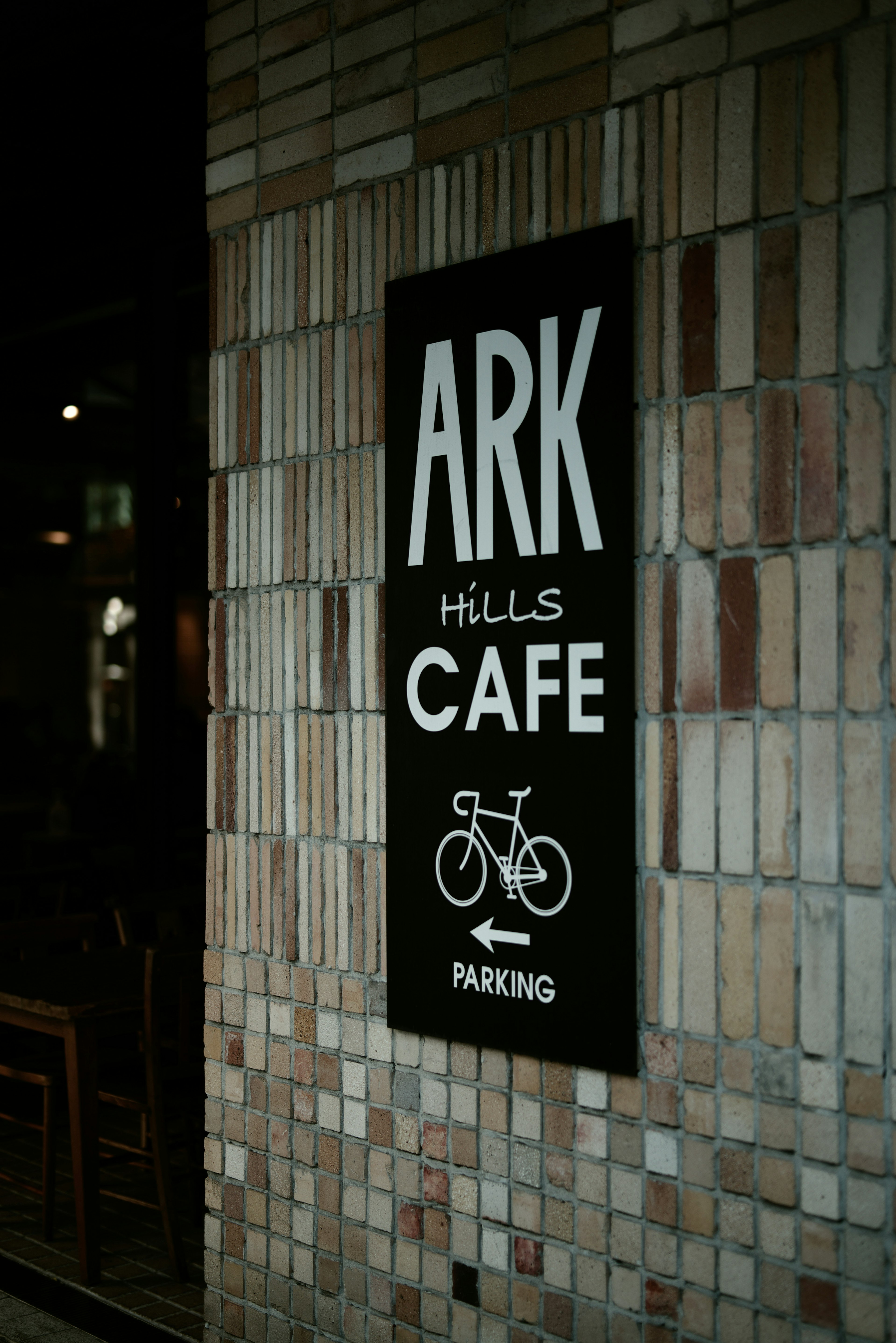 Sign for ARK HILLS CAFÉ on a brick wall