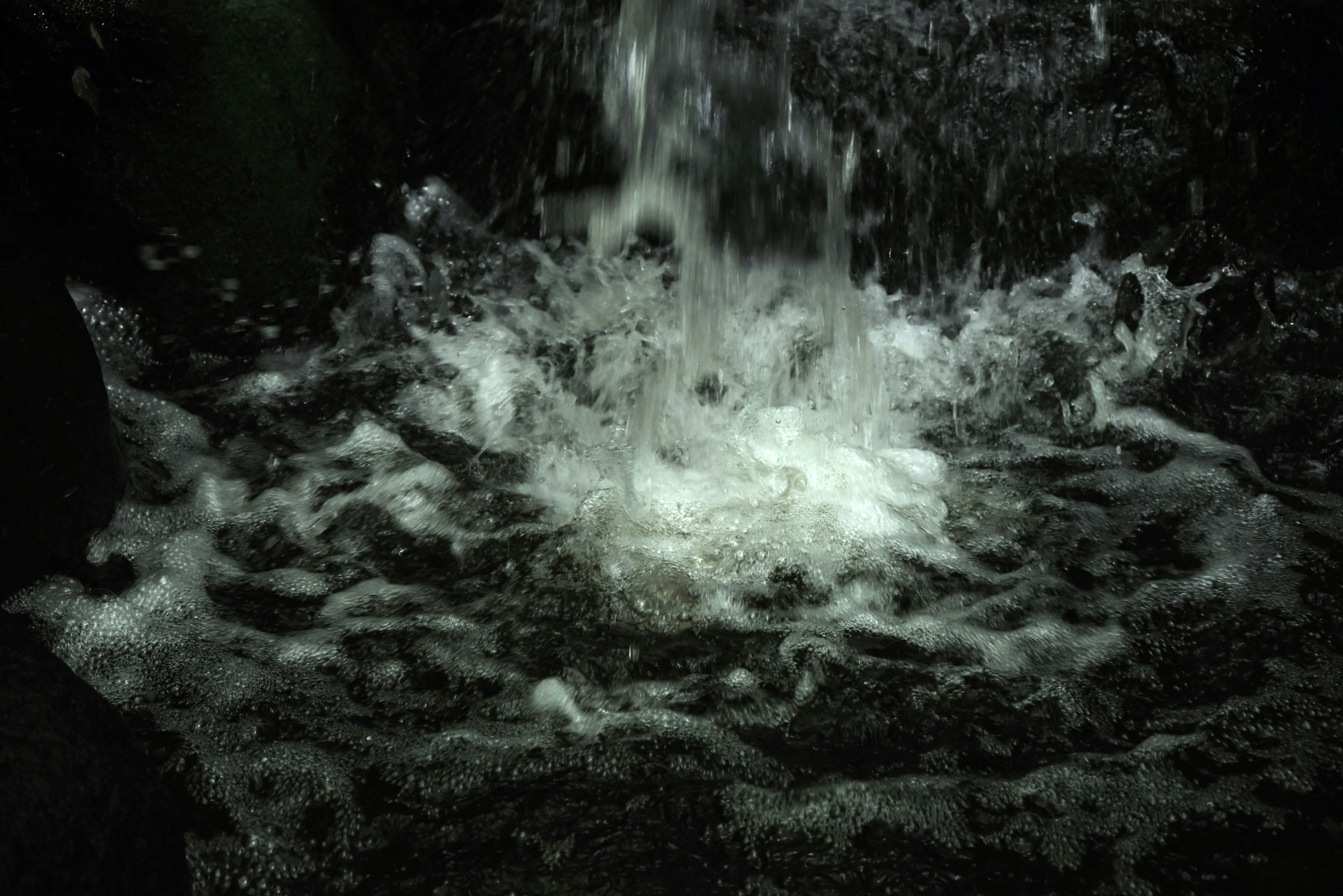 Agua que fluye sobre rocas creando salpicaduras y burbujas