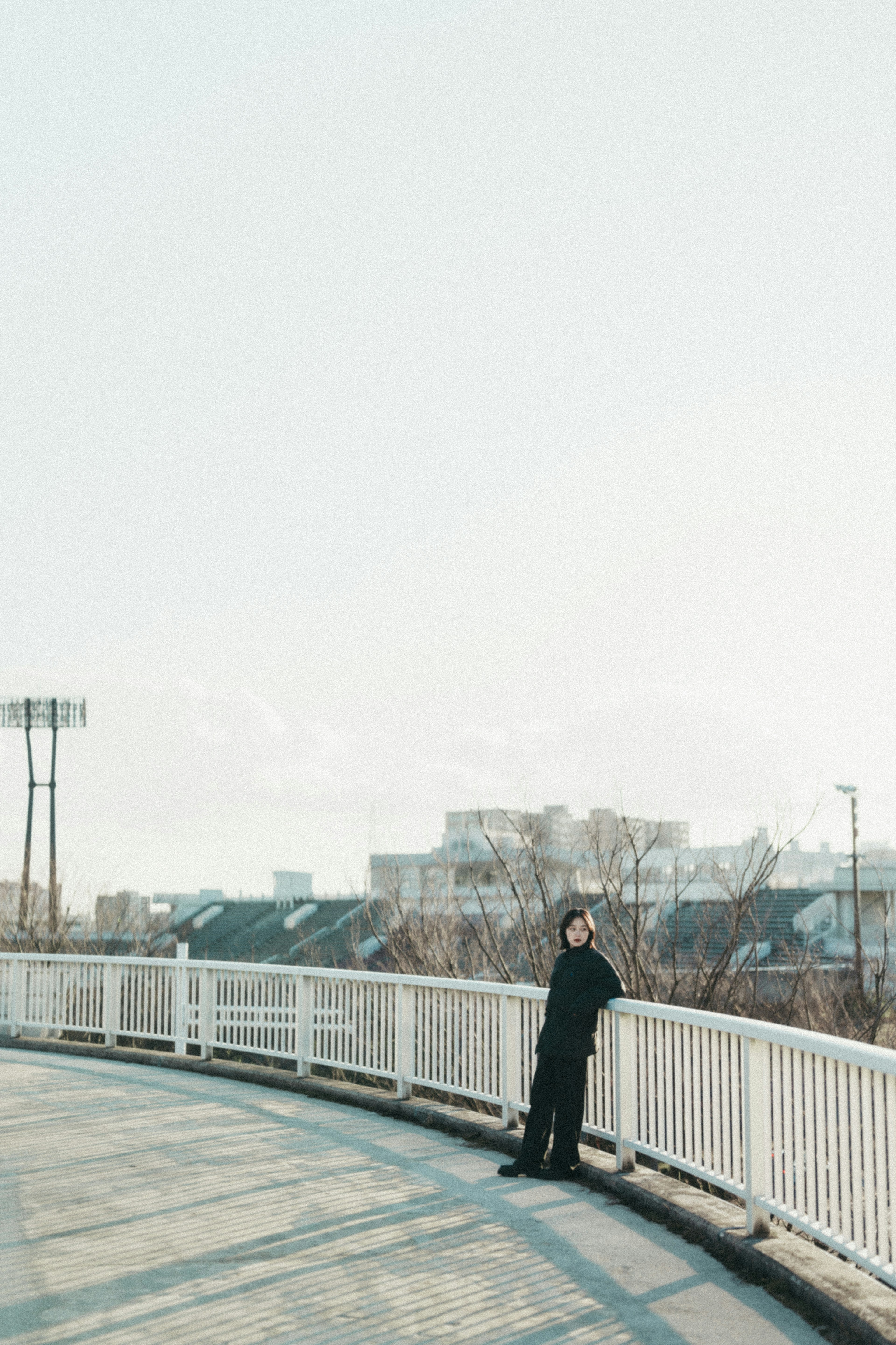 Person in black clothing looking at the sky with a bright background