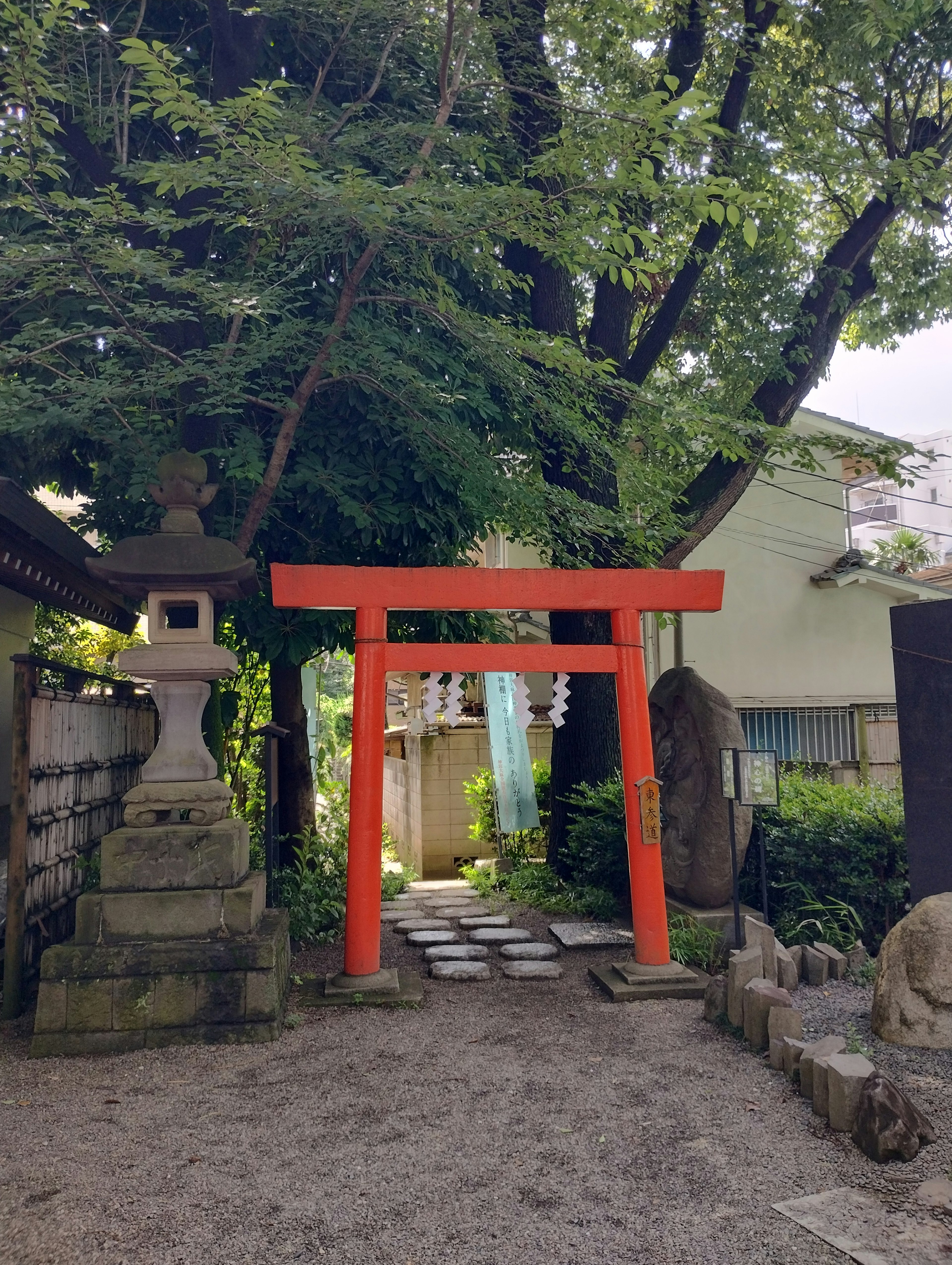 Cổng torii đỏ tại lối vào đền với đèn đá