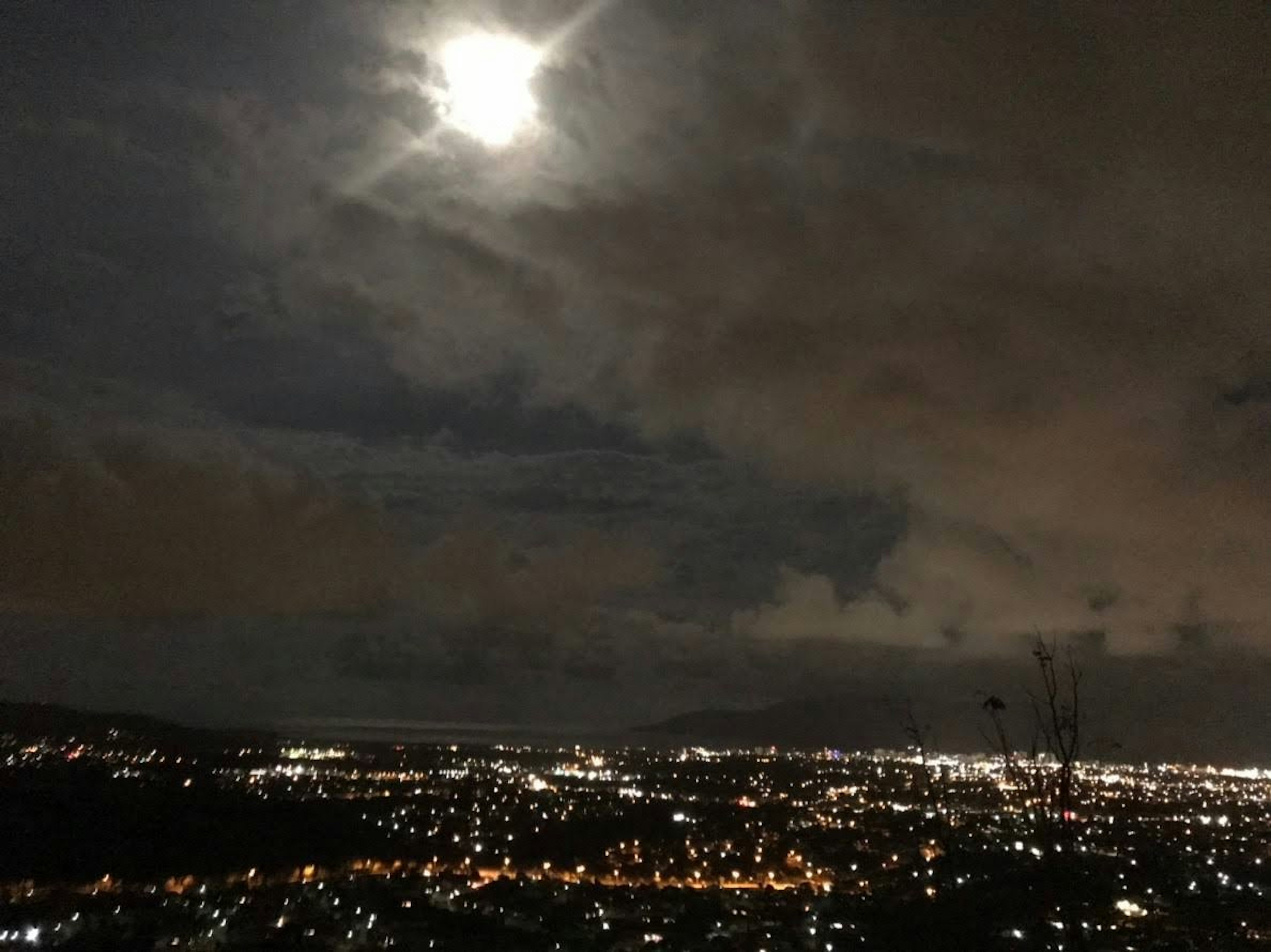 Langit malam yang diterangi bulan di atas pemandangan kota