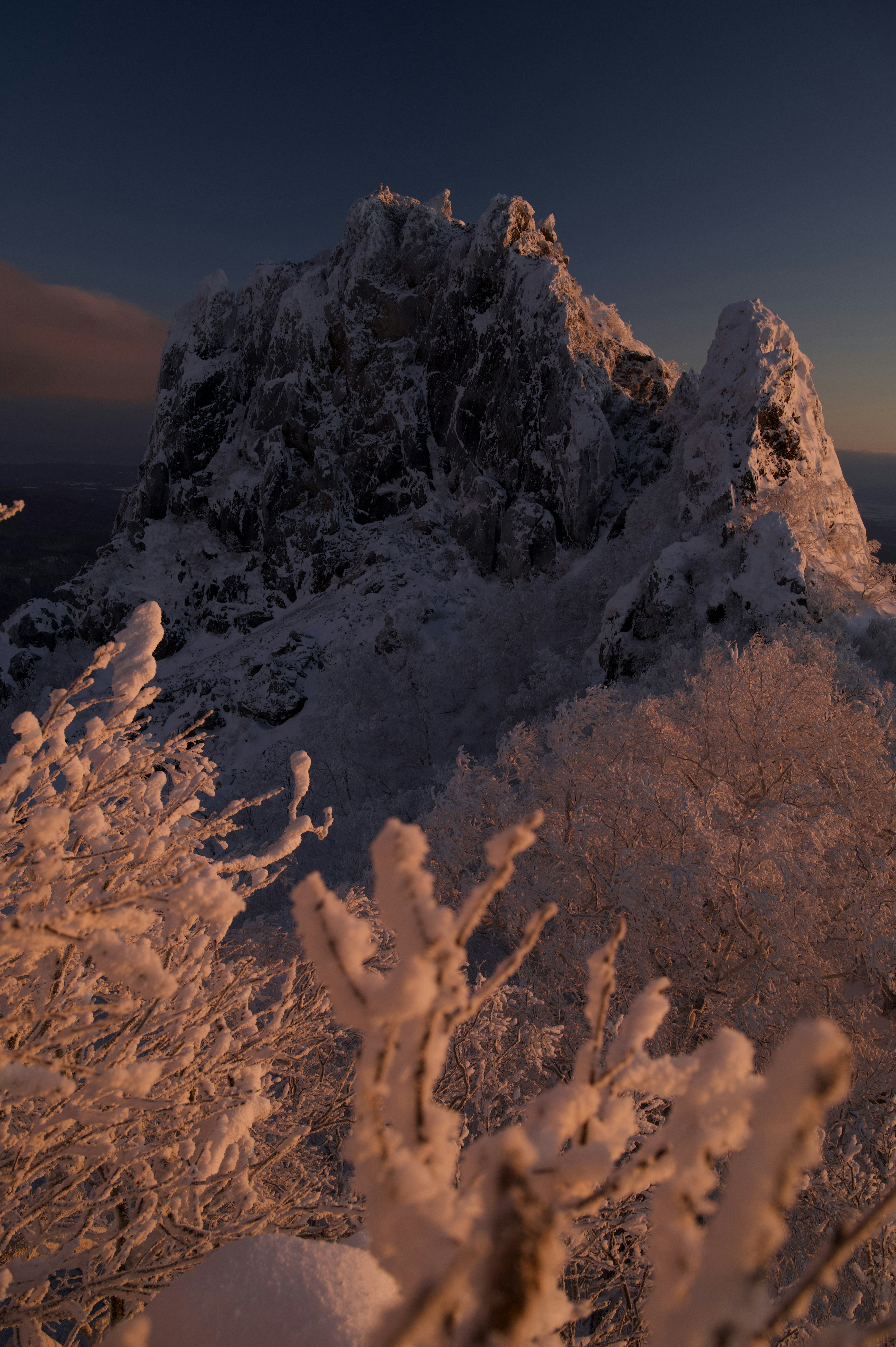 雪に覆われた岩山の風景と夕日の柔らかい光