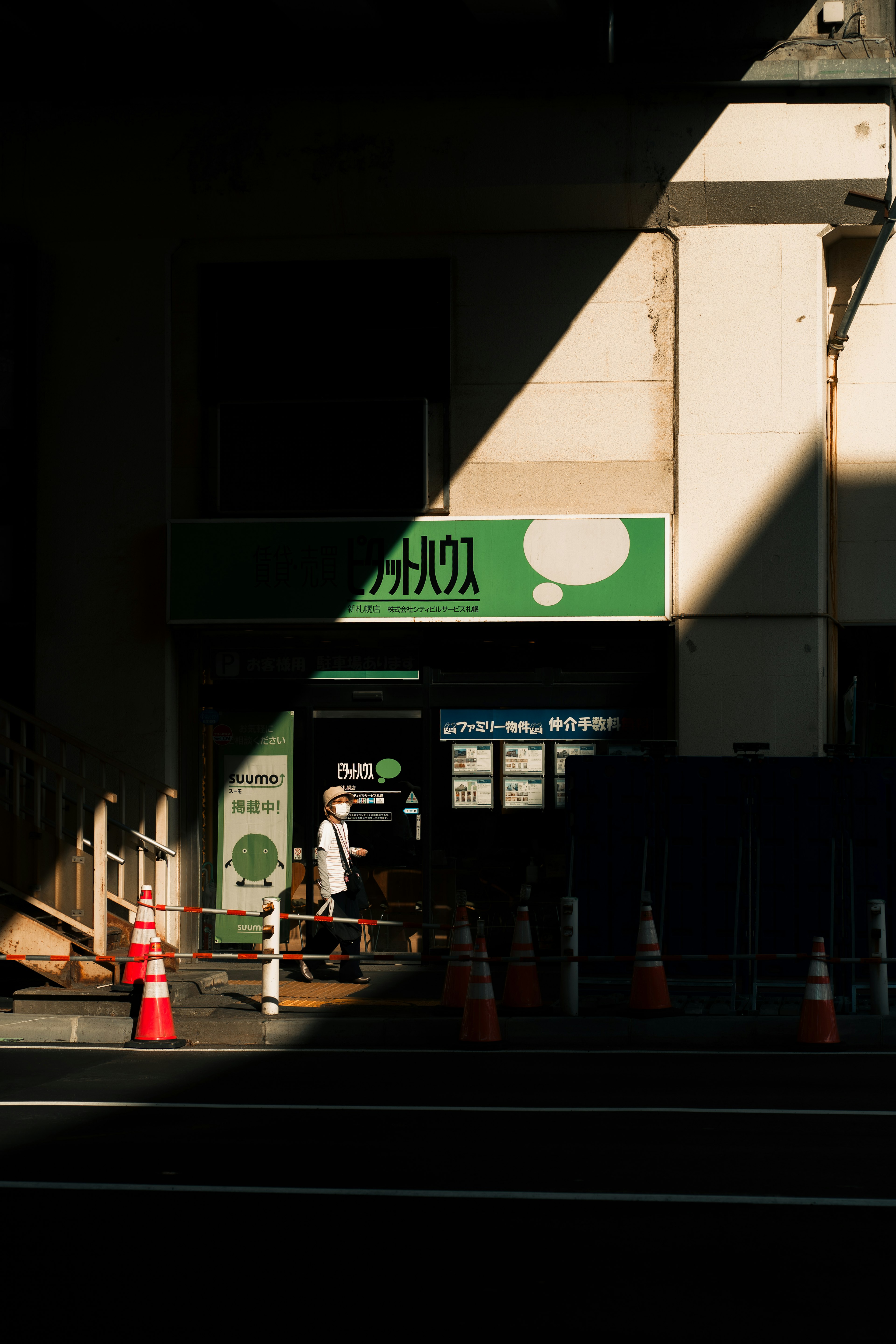 Scena urbana con un segnale verde e la silhouette di una persona nell'ombra