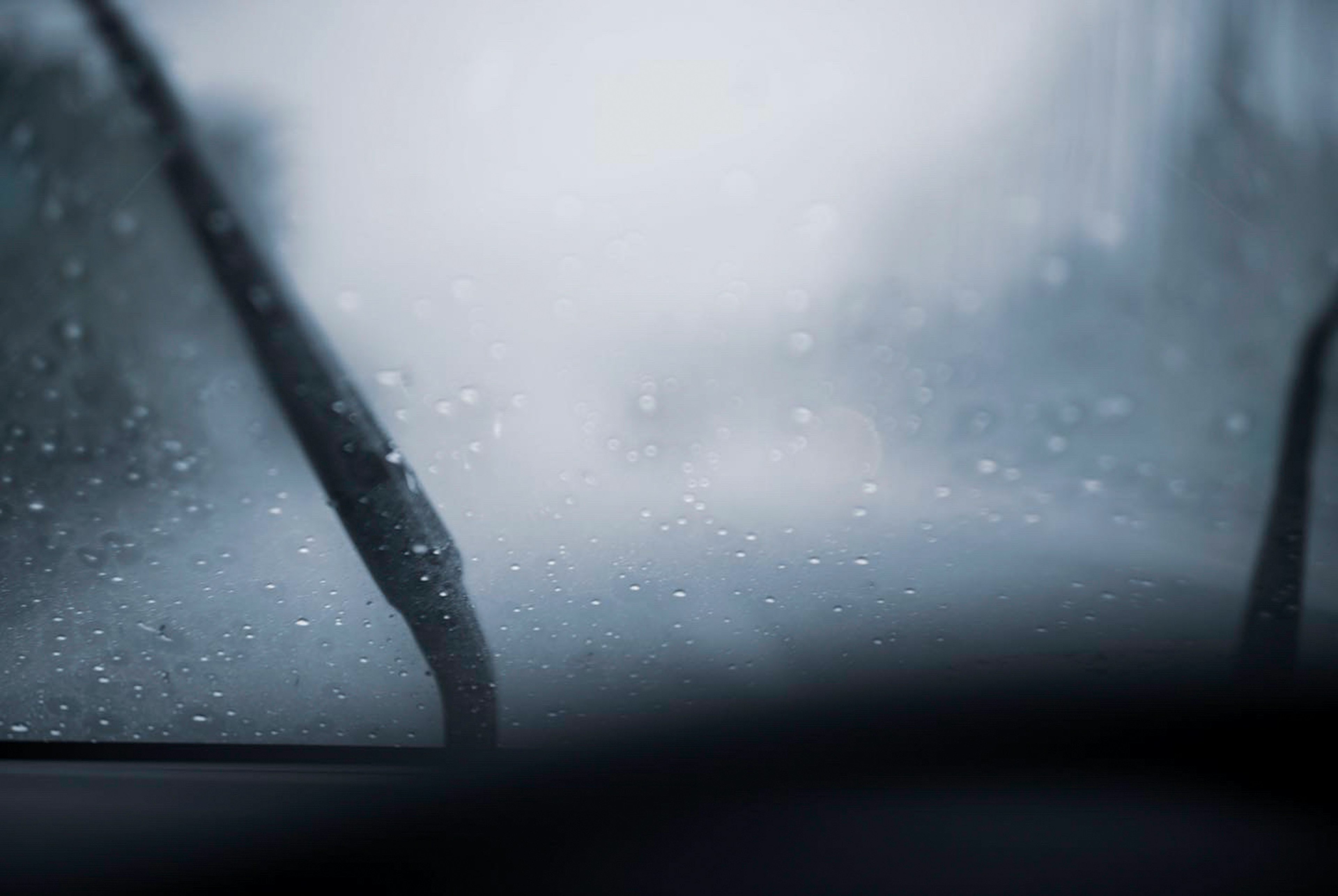 Primer plano de un parabrisas de coche en la lluvia visibilidad borrosa