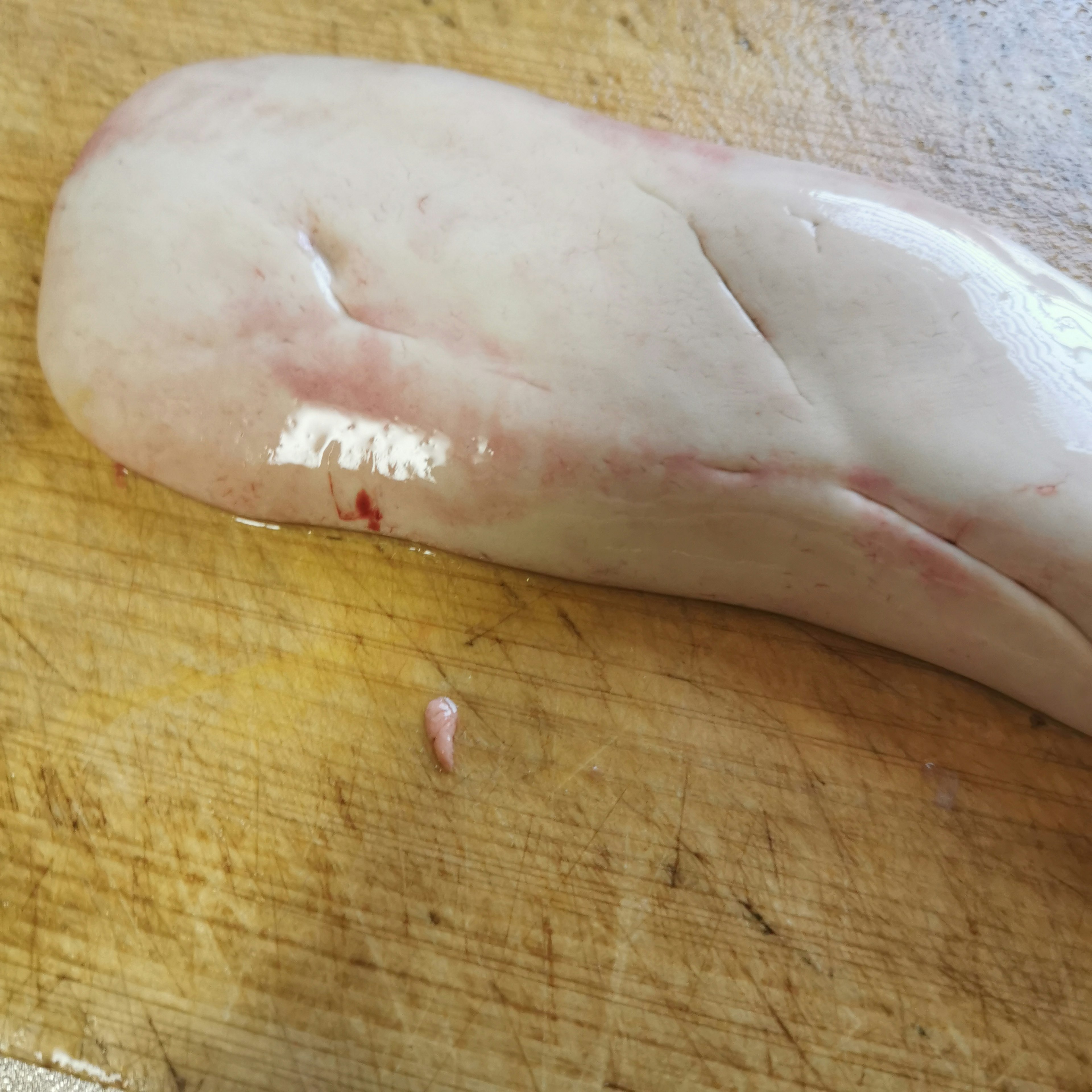 A piece of meat resting on a wooden cutting board