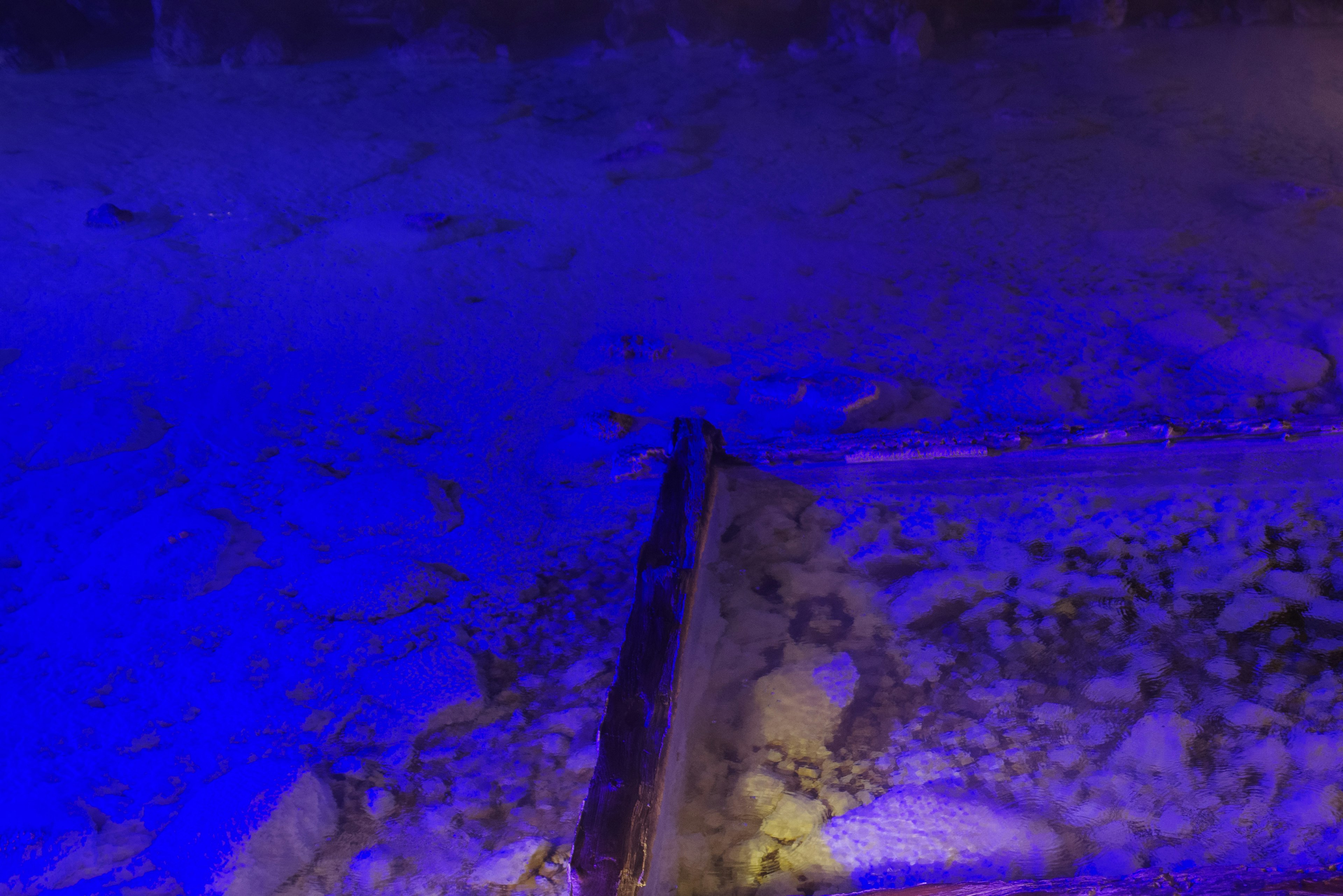 Landscape of rocks and sand under blue lighting