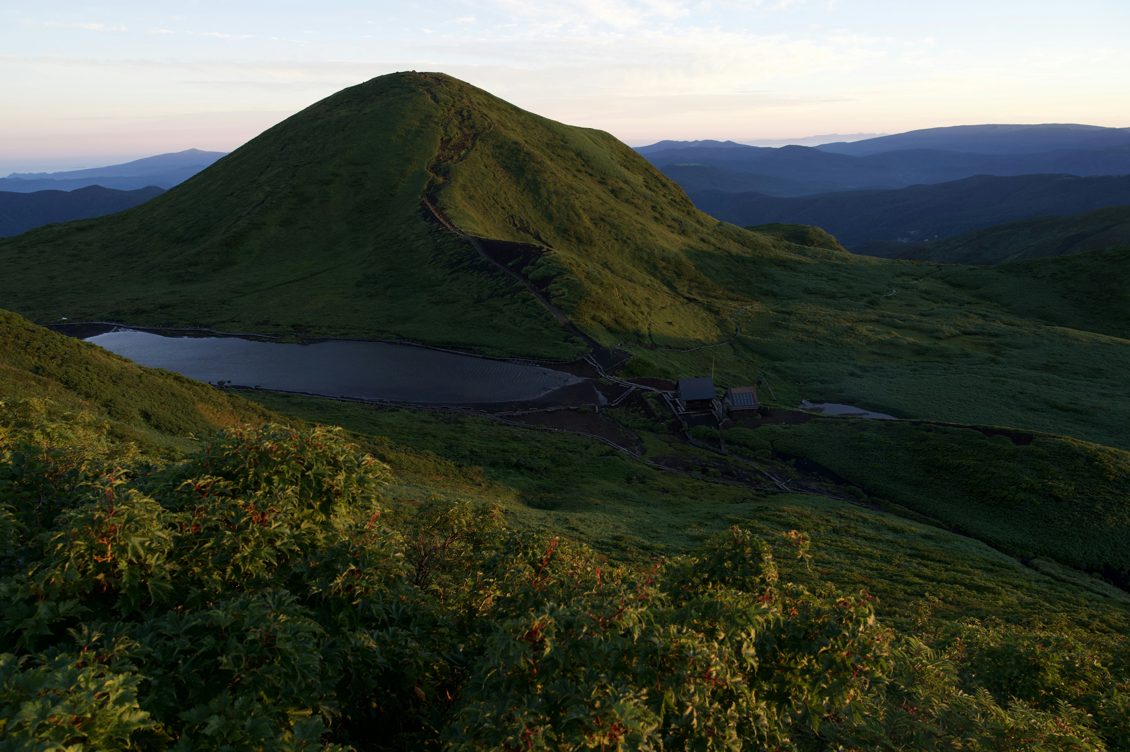 Malersiche Aussicht auf einen grünen Hügel und einen ruhigen See