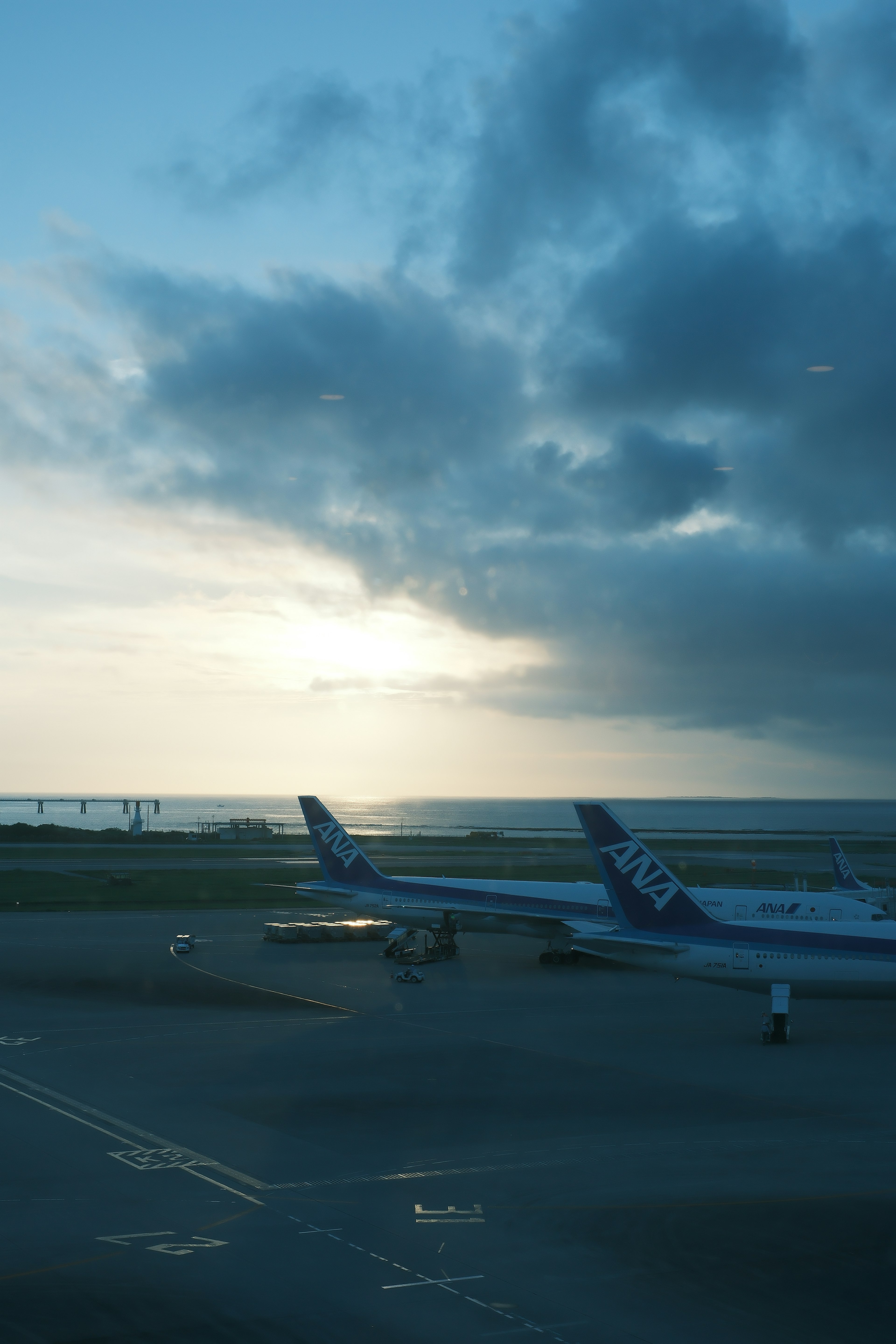 空港の夕暮れ時の風景に停まる航空機と海