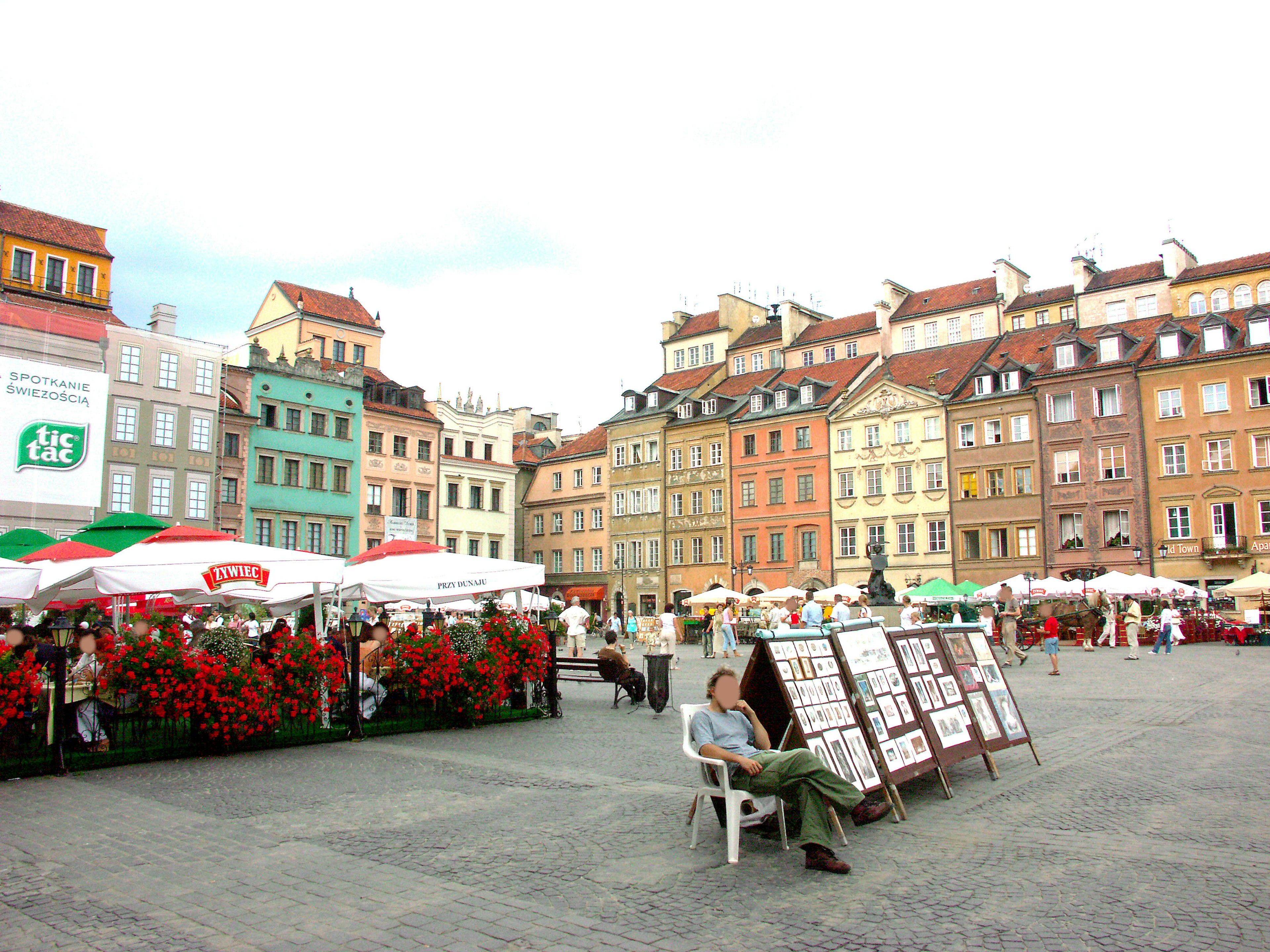 Vibrant square with colorful buildings and flower decorations featuring outdoor seating