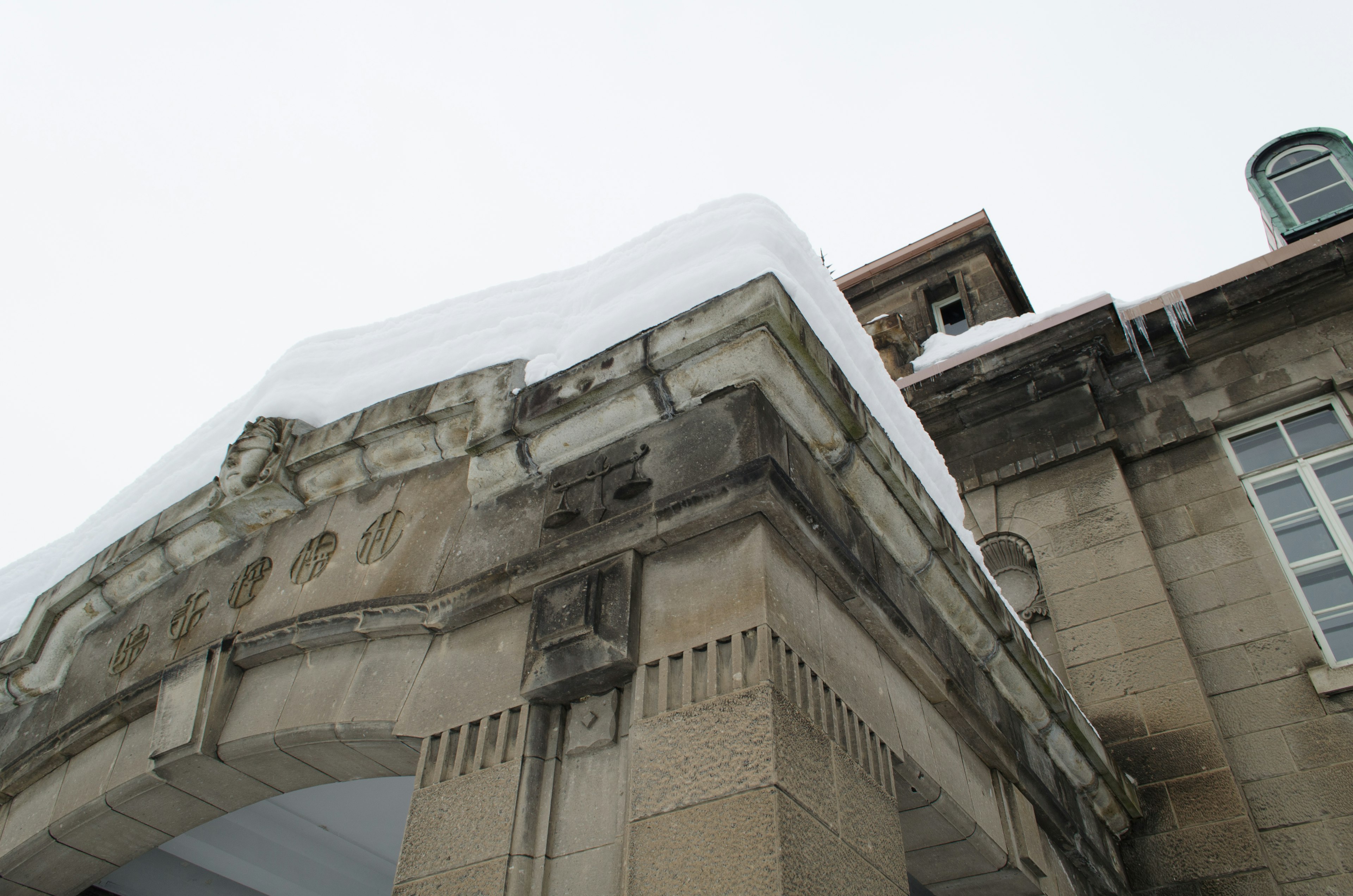 Snow-covered building with decorative arch and roof