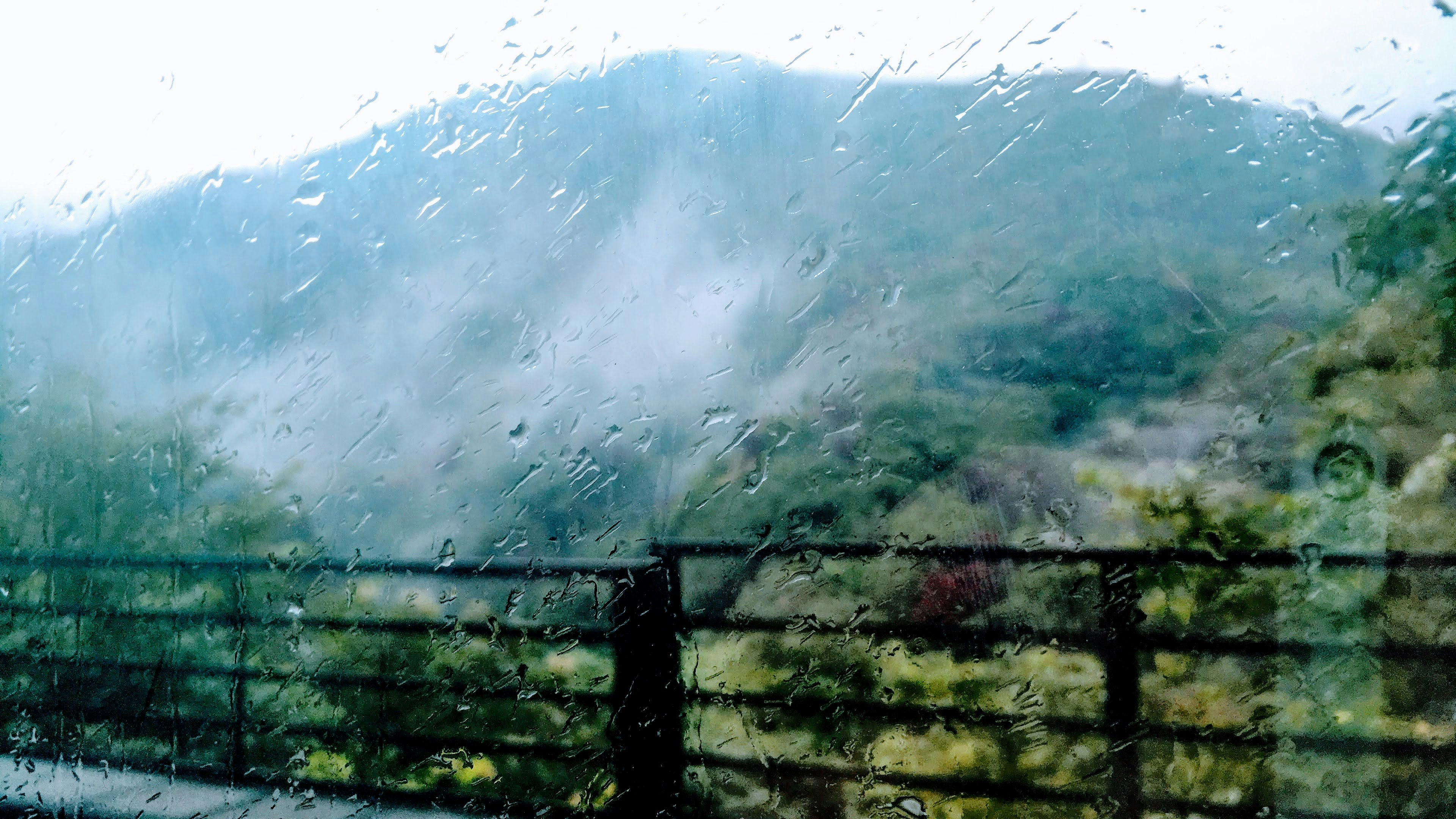 Mountains and mist seen through a rain-soaked window