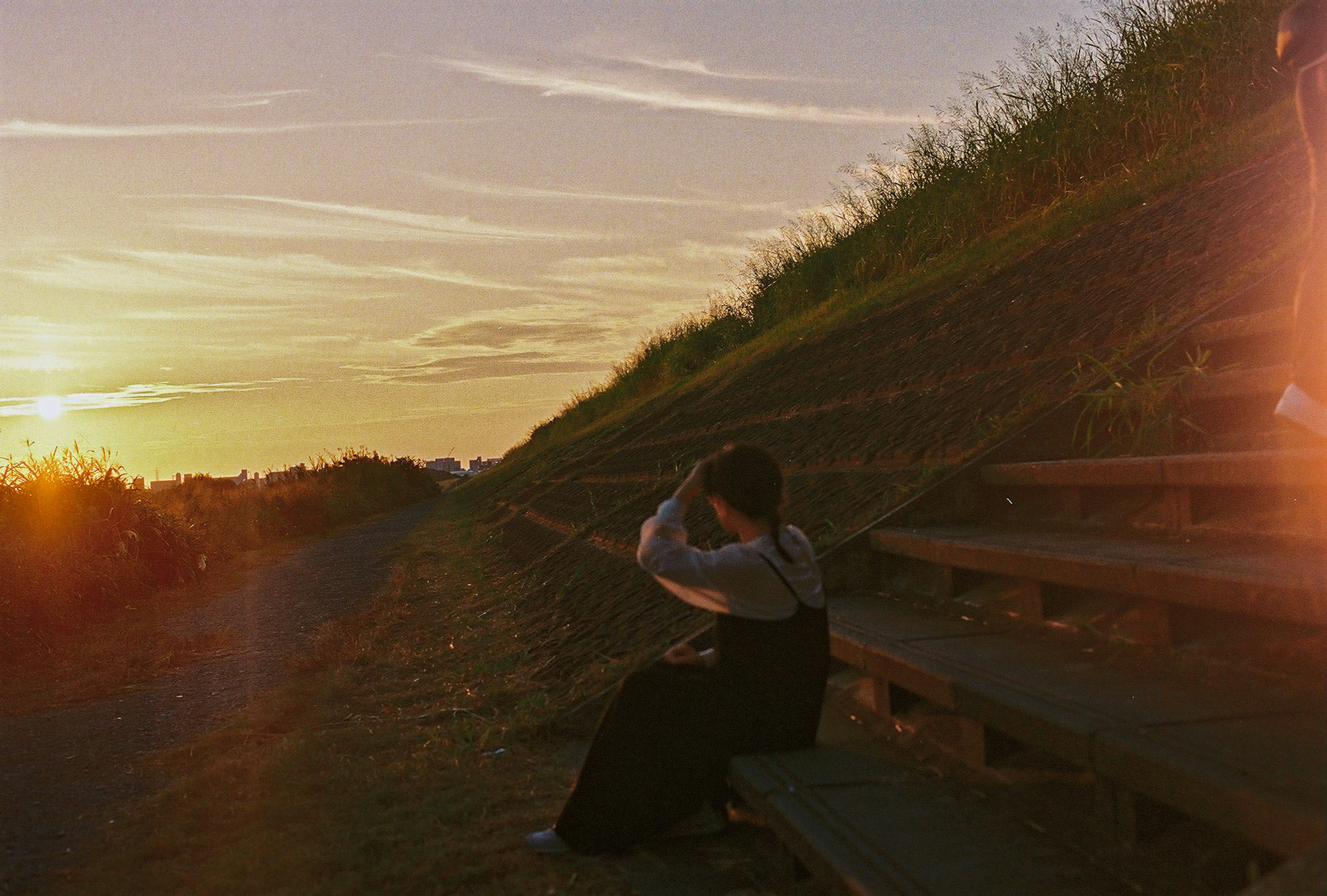 Silhouette of a person sitting on steps during sunset