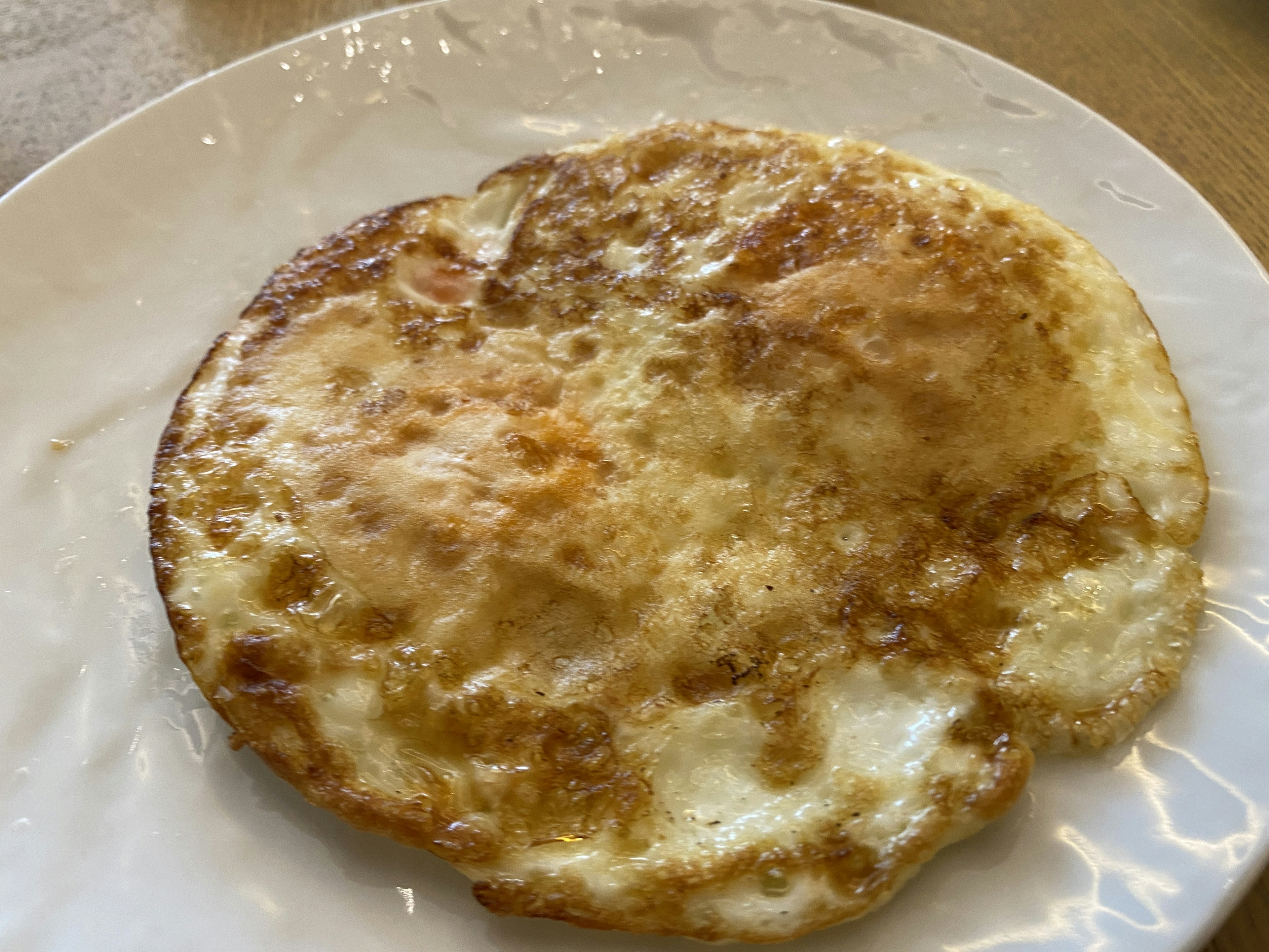 Oeuf frit sur une assiette blanche