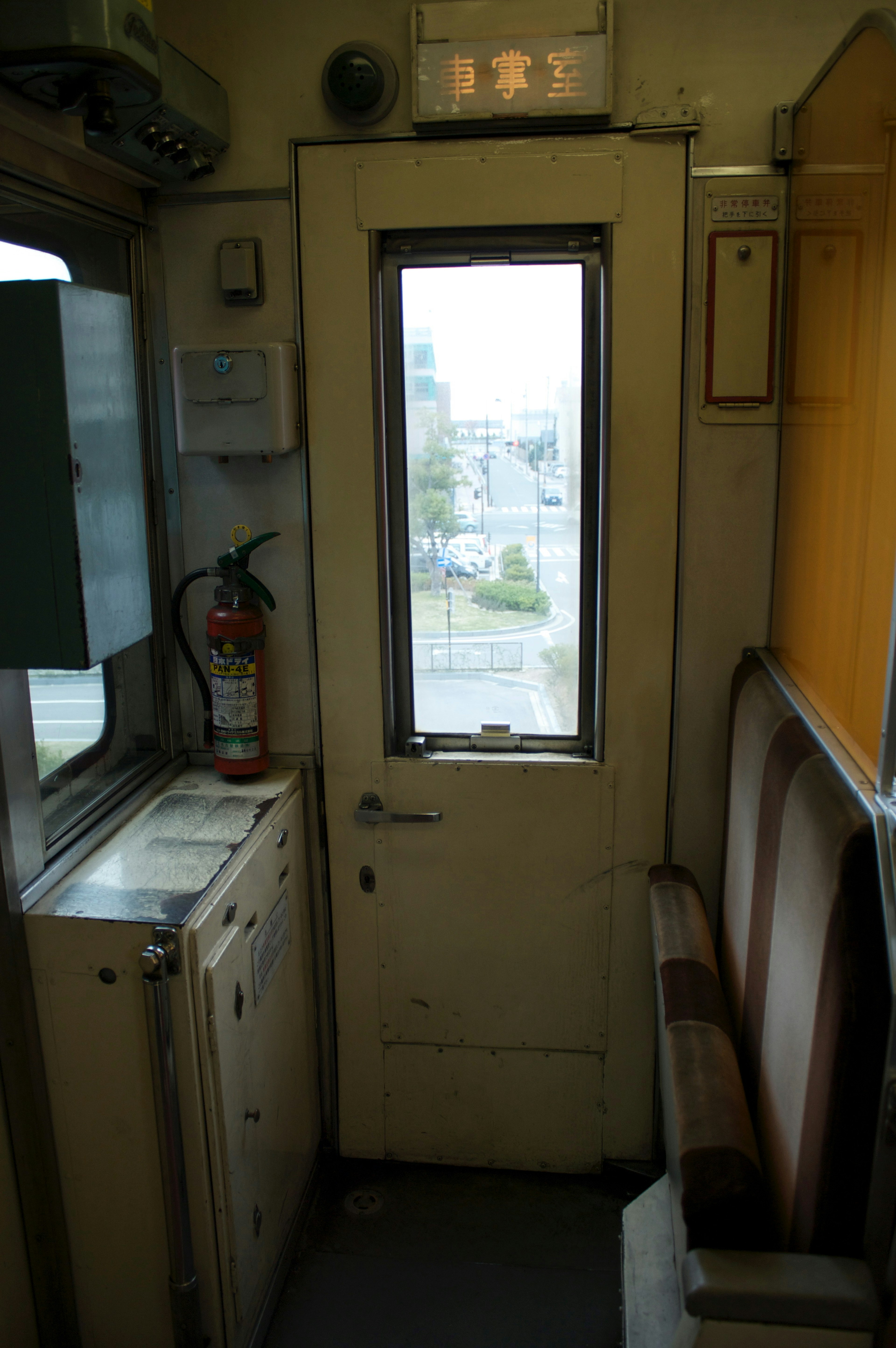 Vista interior de un vagón de tren mostrando una puerta y una ventana