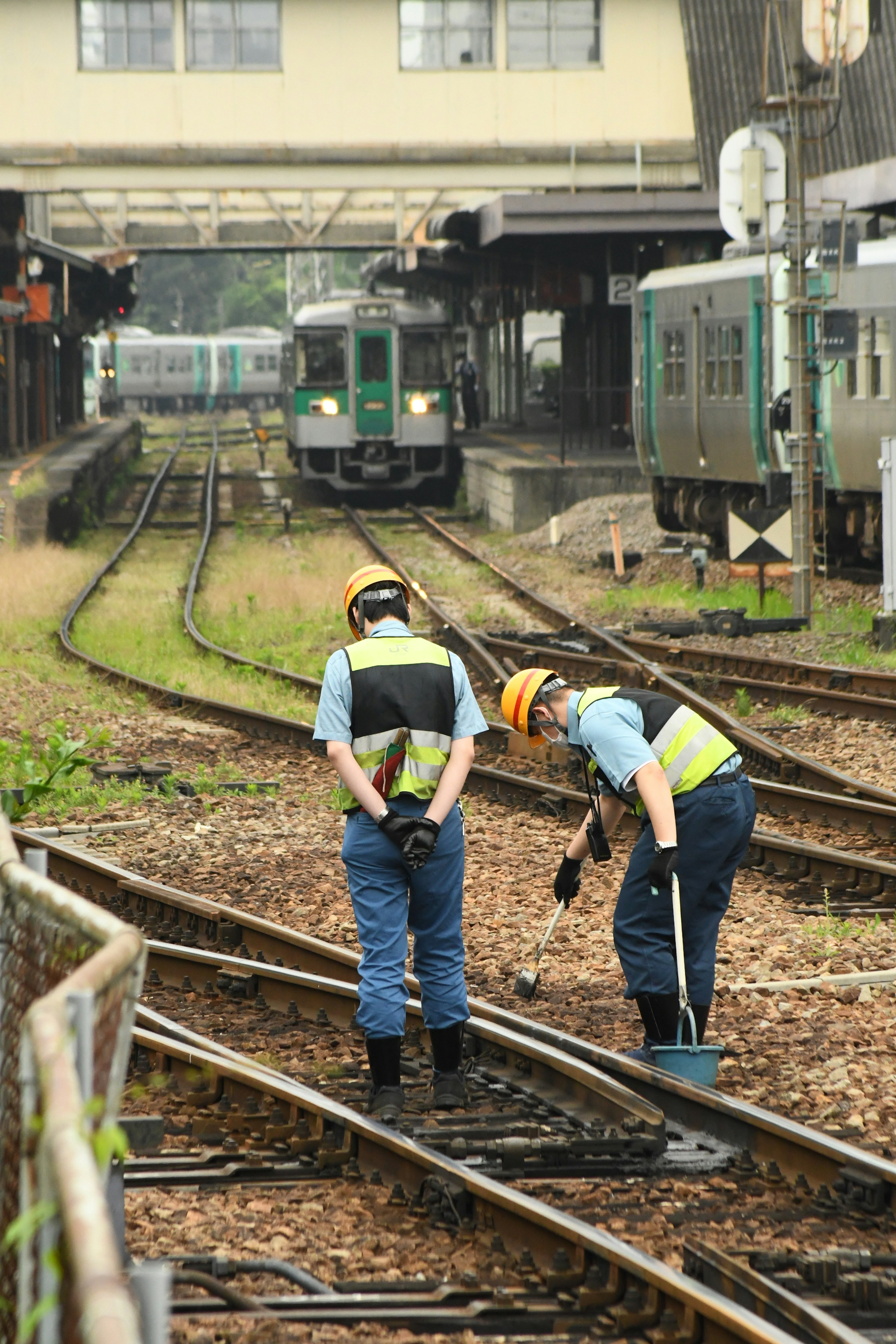 Pekerja kereta api memeriksa rel di stasiun