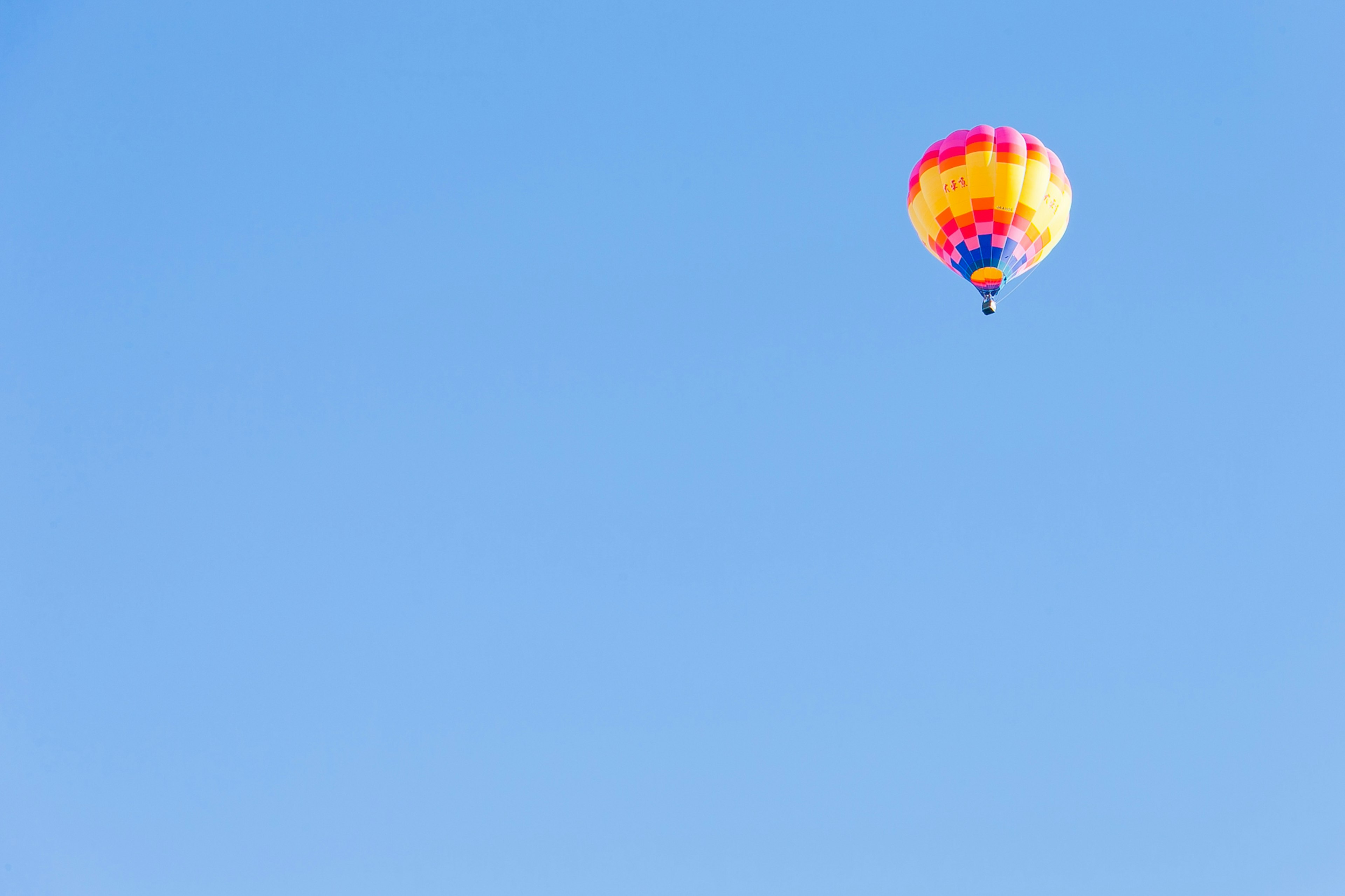 Balon udara berwarna-warni mengapung di langit biru