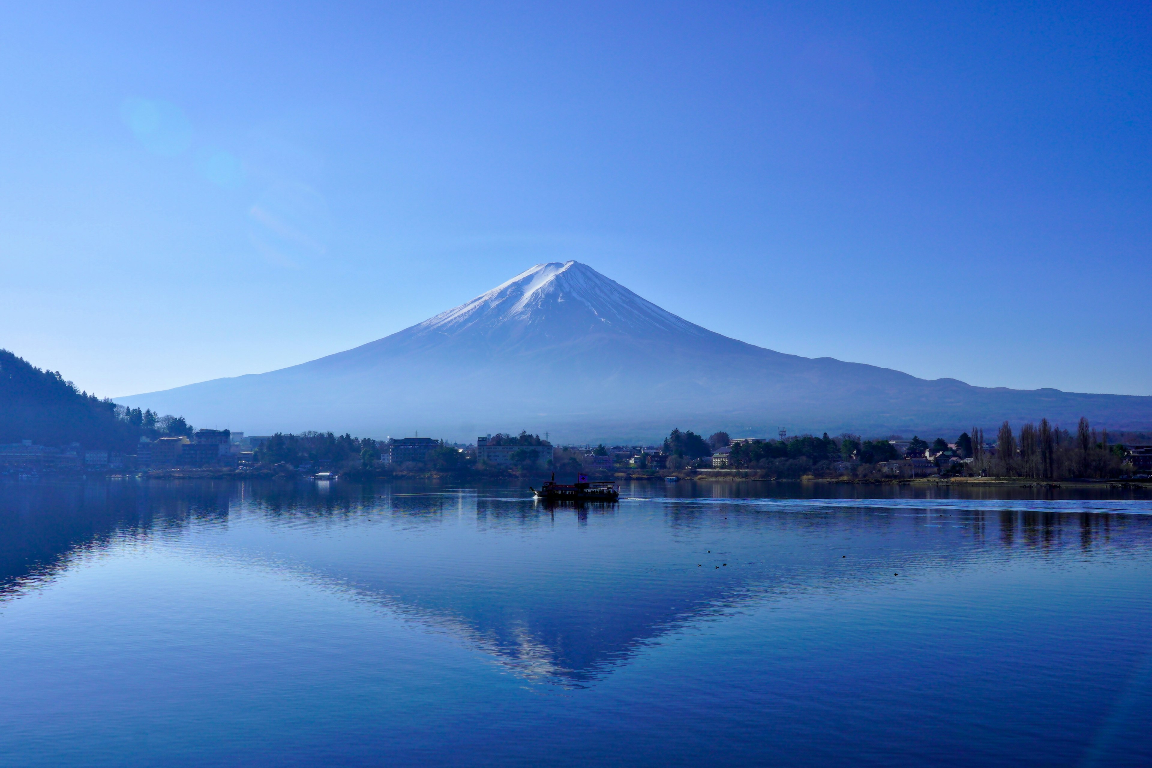 Vista panoramica del Monte Fuji con cielo blu chiaro che si riflette sul lago