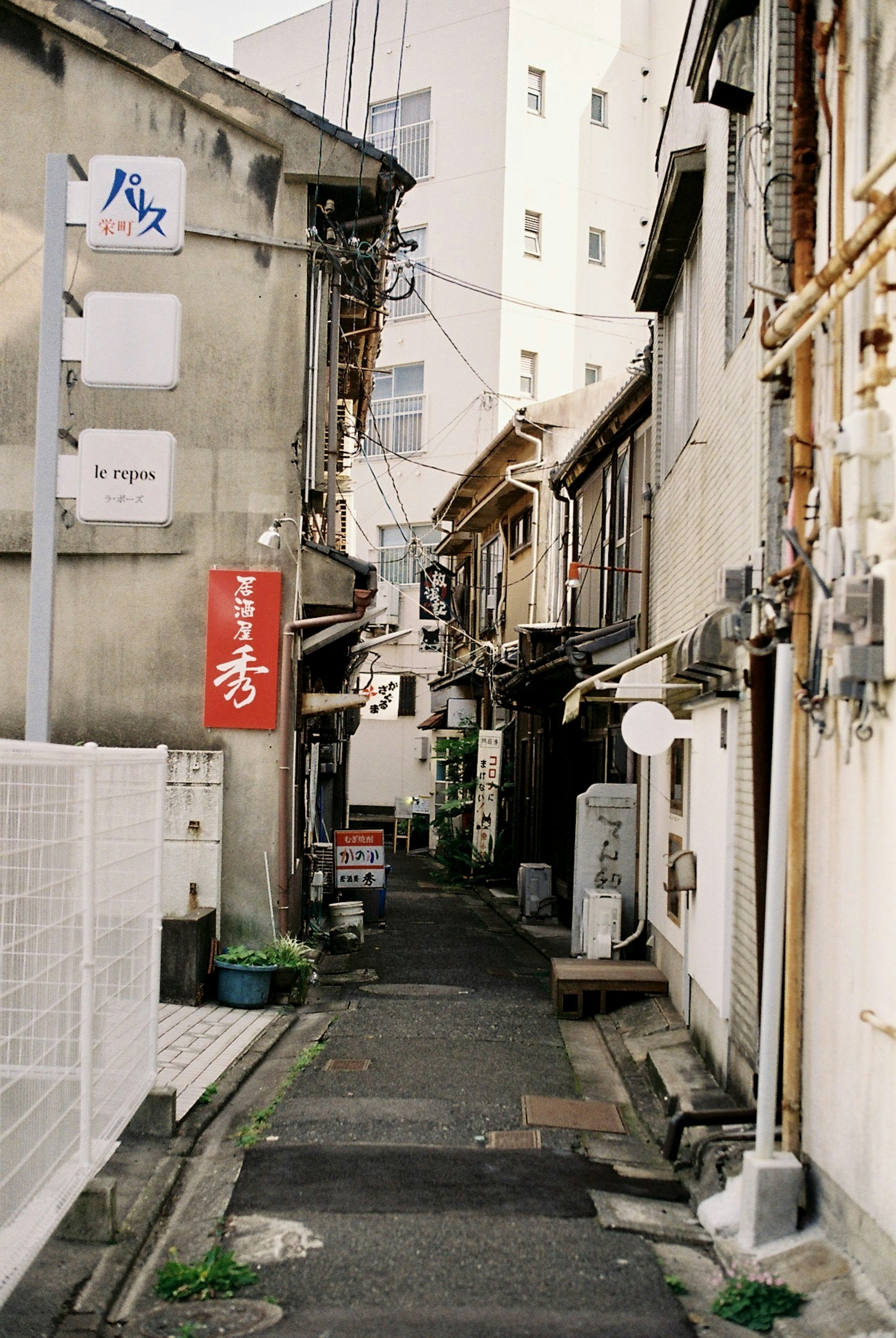 狭い路地に沿った古い建物と看板がある風景