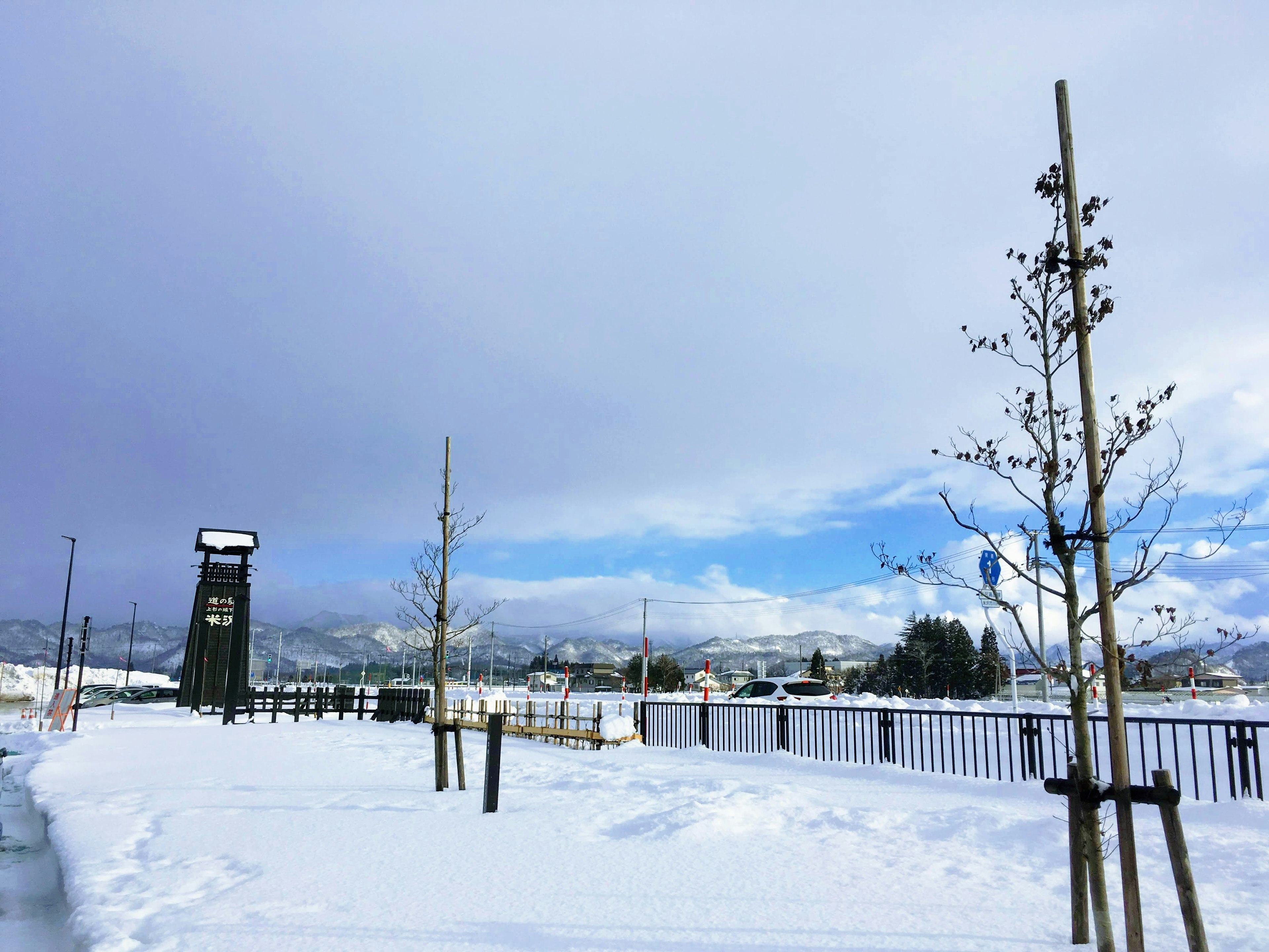 Paesaggio di parco innevato con cielo blu e montagne in lontananza