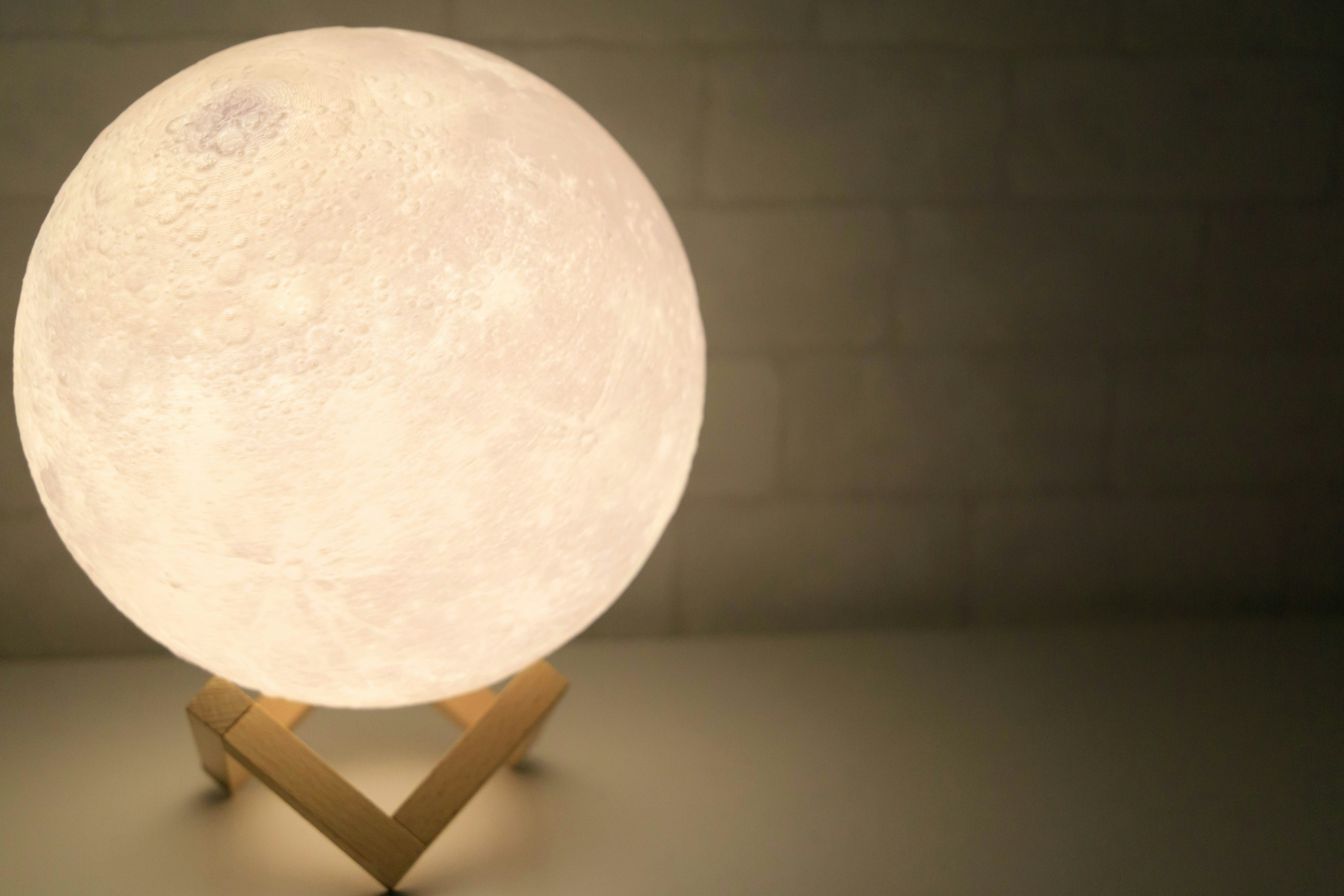 Bright moon-shaped lamp on a wooden stand