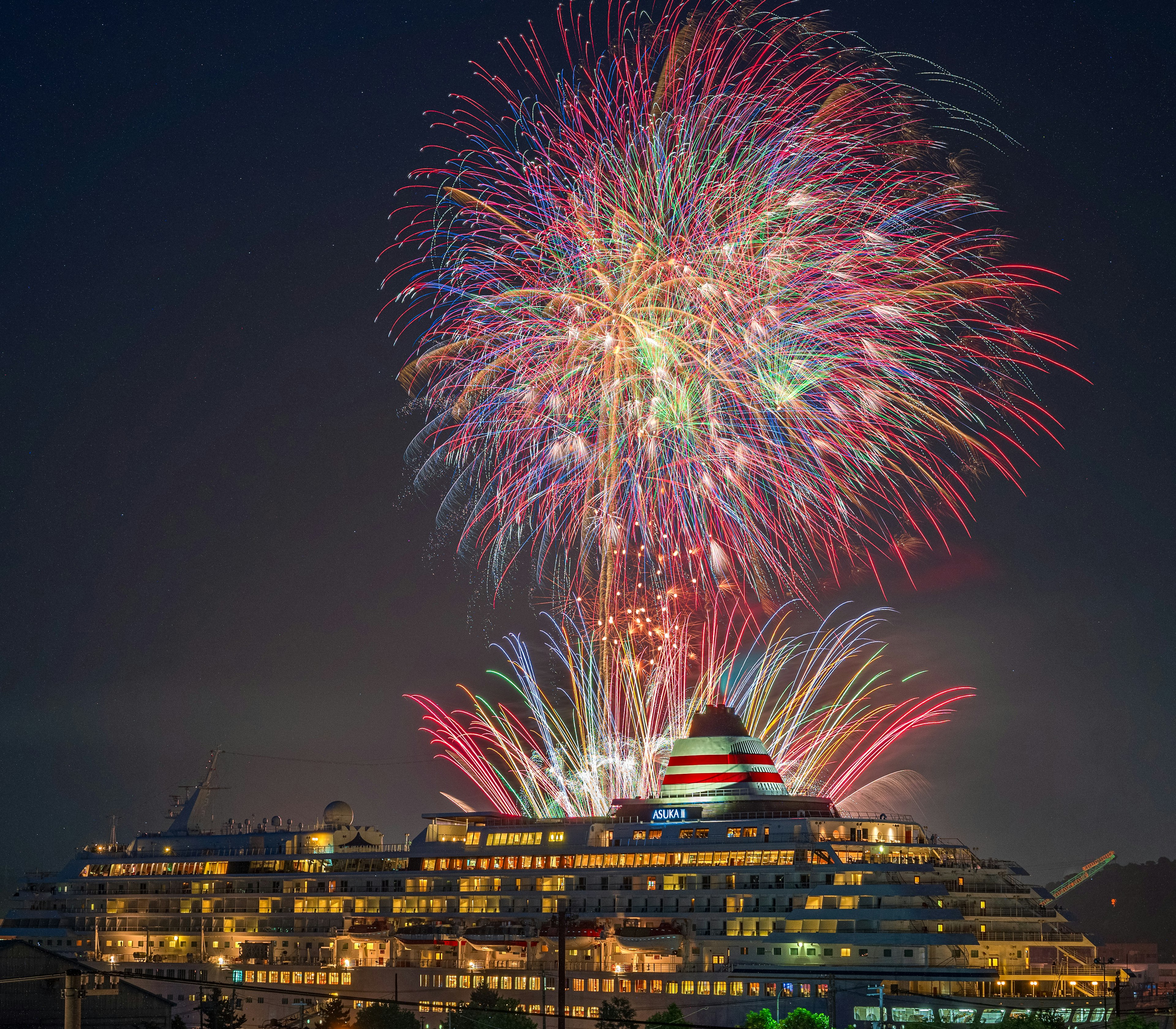 Spectacle de feux d'artifice au-dessus d'un luxueux navire de croisière la nuit