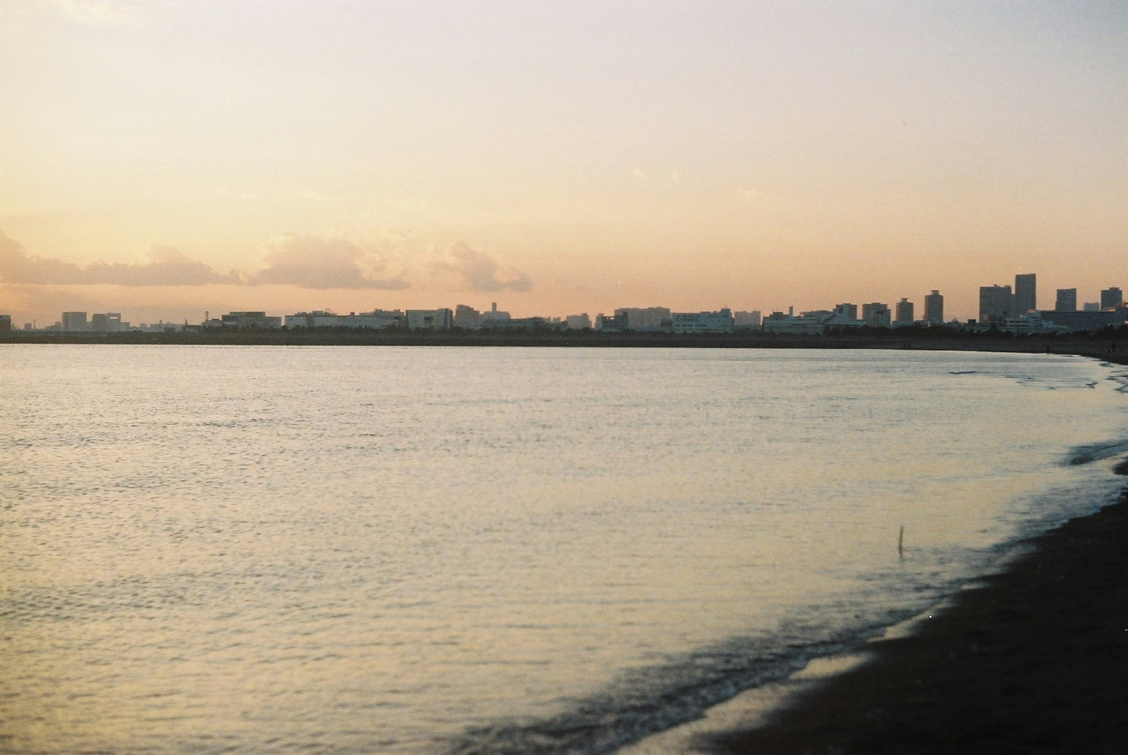 夕暮れ時の海と都市のシルエット