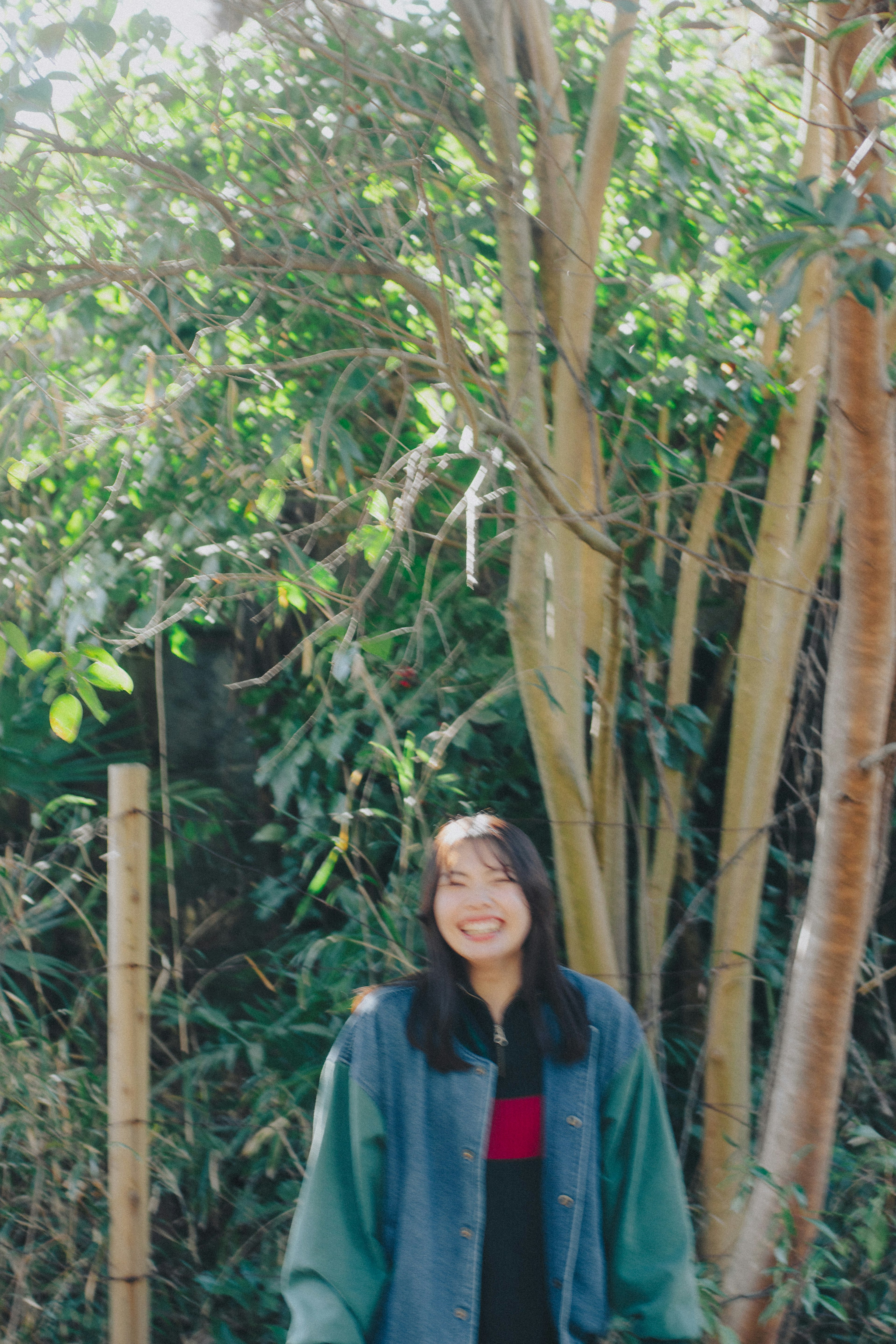 Smiling woman standing in front of green trees